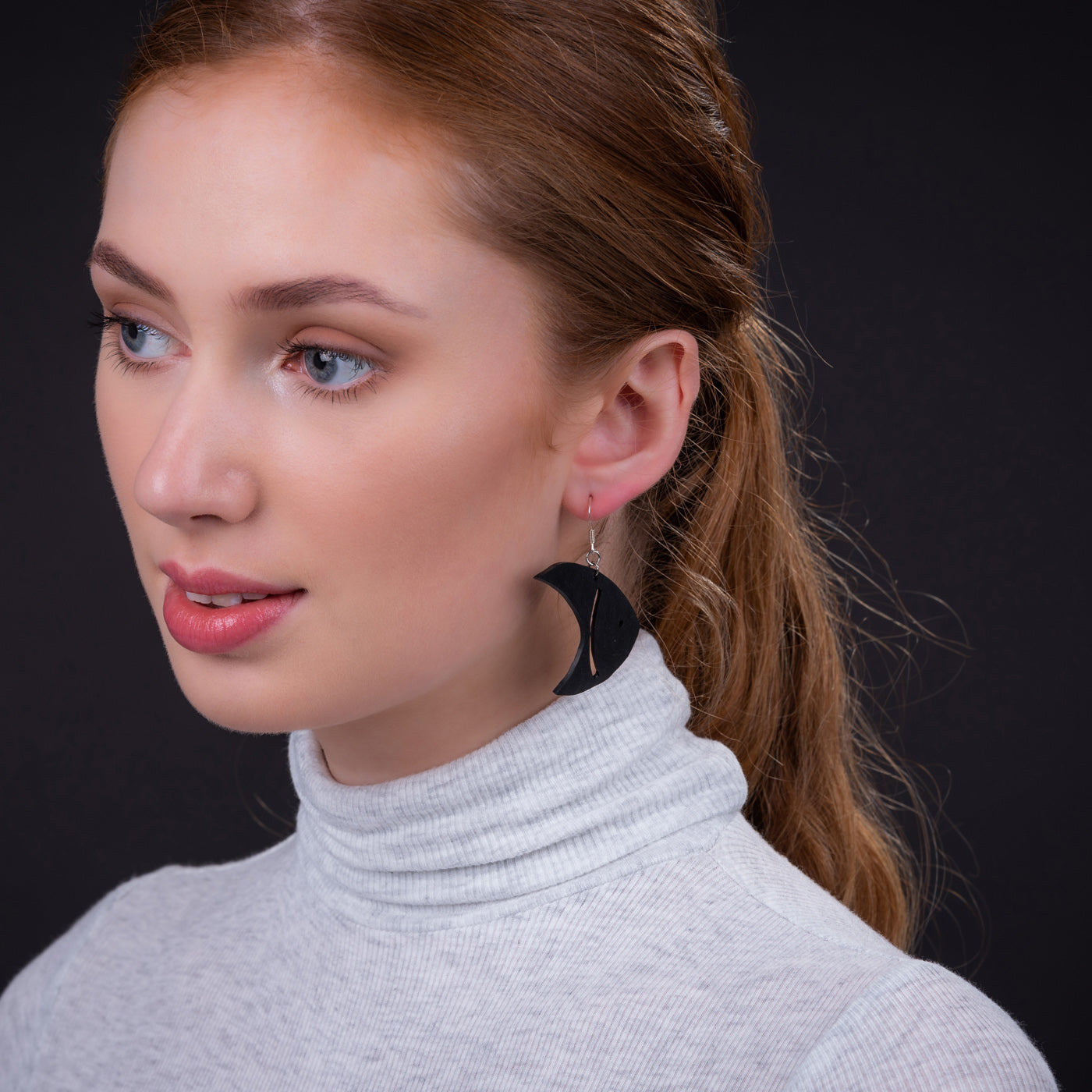 A pair of eco-friendly Pisces Recycled Rubber Fish Earrings, handcrafted from reclaimed rubber with sterling silver hooks, showcasing a playful fish design.