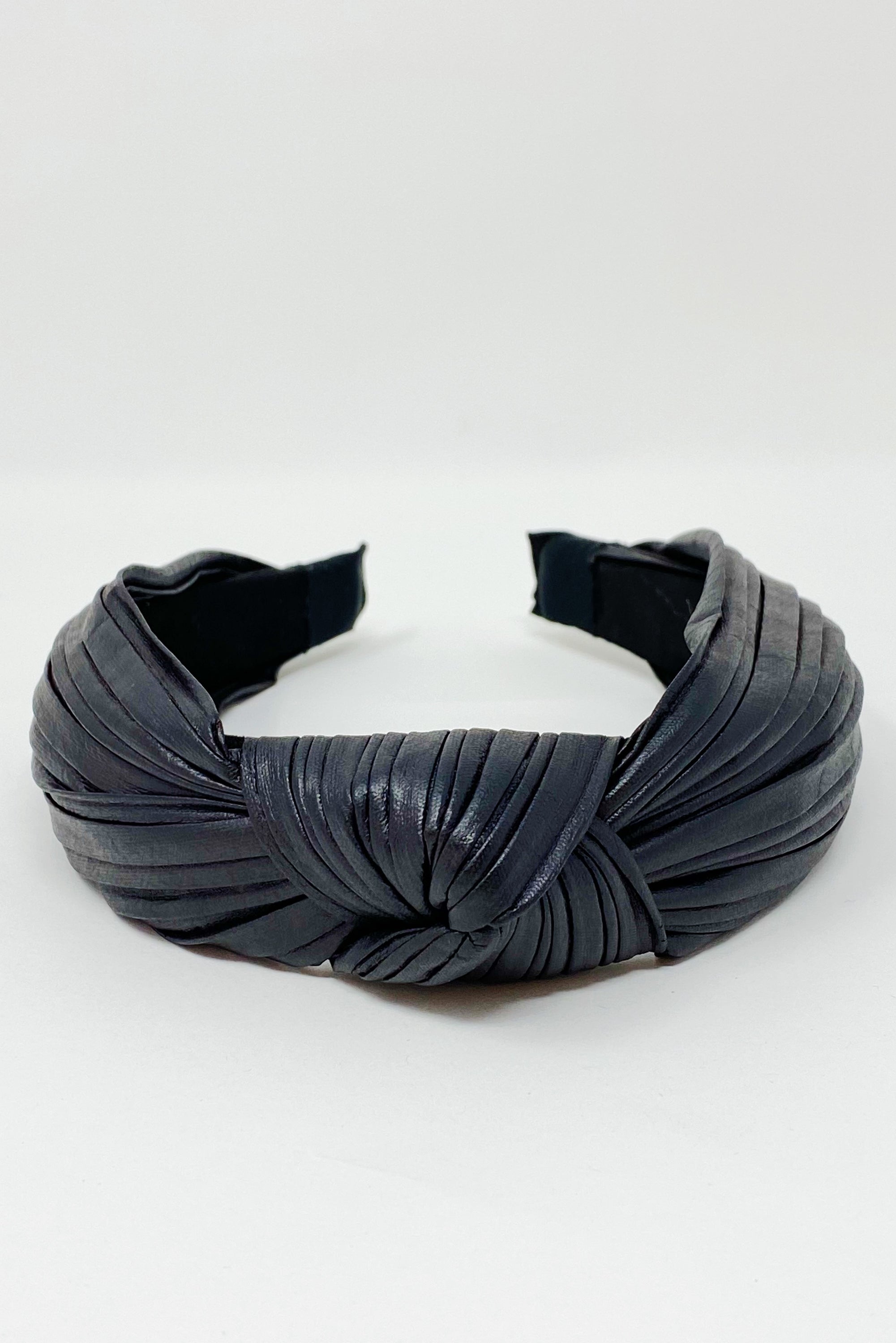 Plenty Pleats Headband featuring leather-like pleated fabric in a chic knotted design, perfect for stylish outfits.