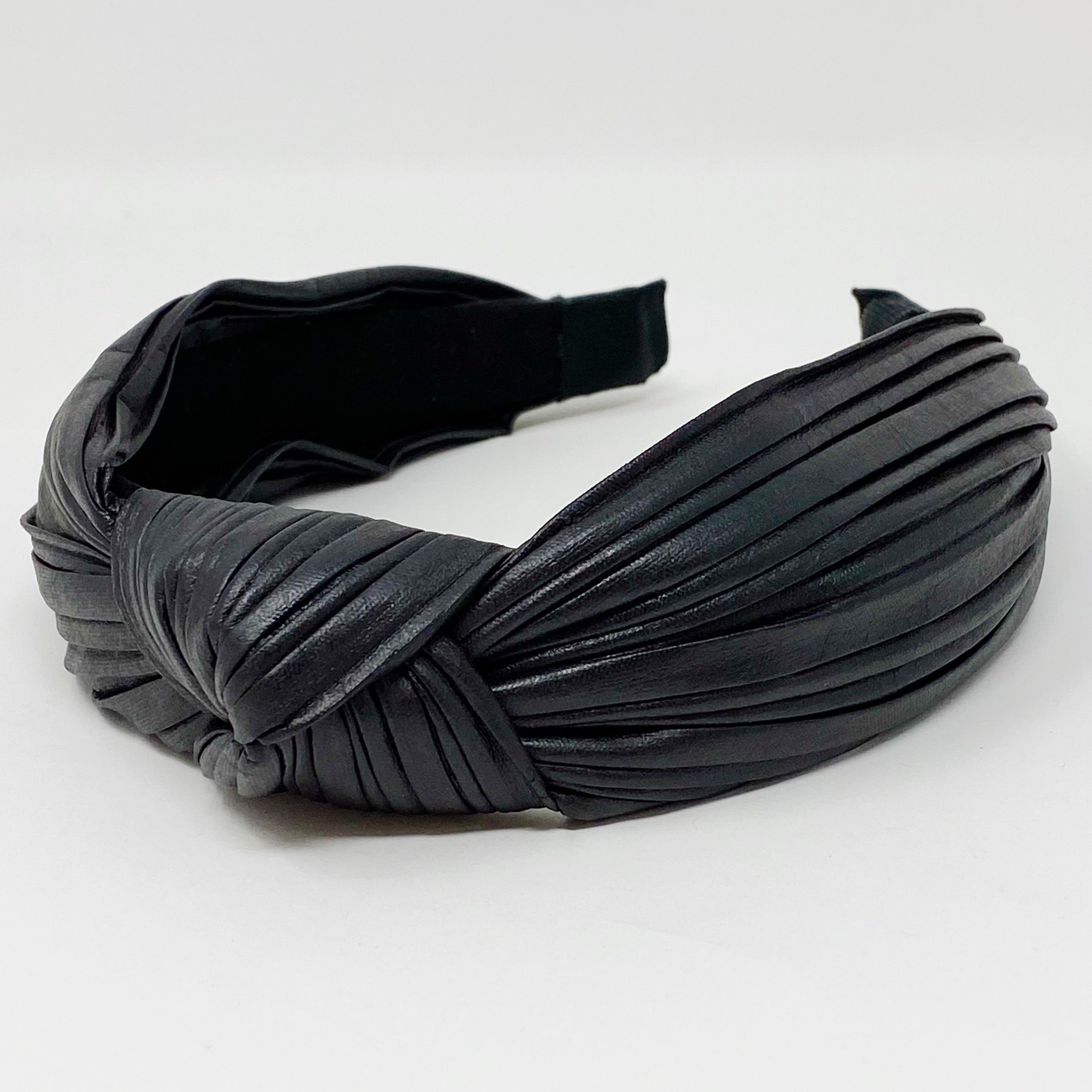 Plenty Pleats Headband featuring leather-like pleated fabric in a chic knotted design, perfect for stylish outfits.