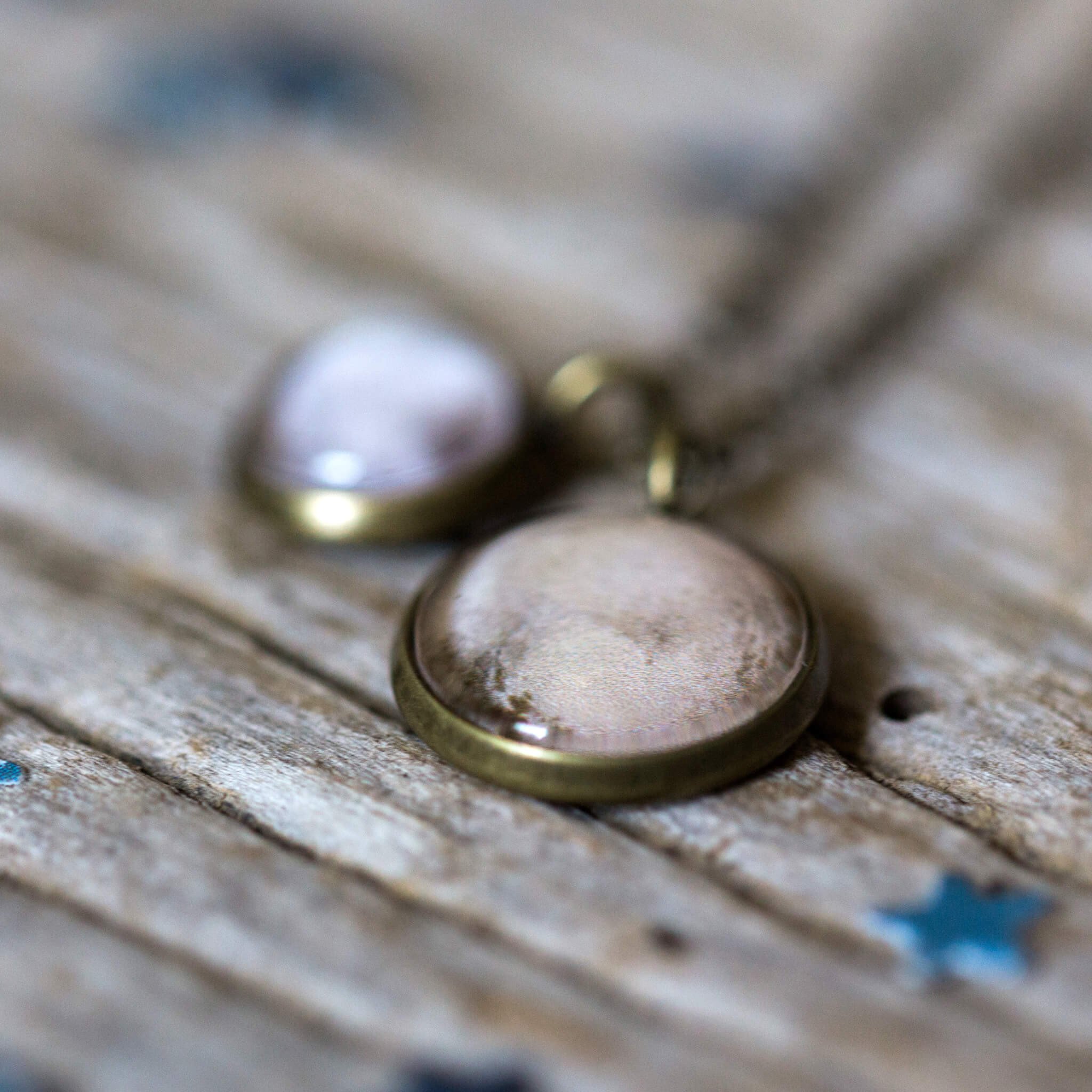 Layered necklace featuring Pluto and its moon Charon, inspired by New Horizons images, handcrafted with plated brass and glass.