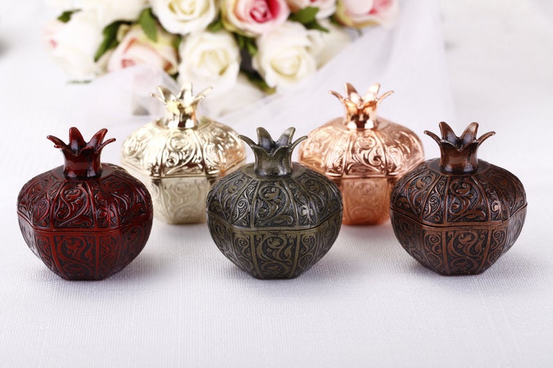 Set of 50 elegant pomegranate wedding favor boxes in various sizes, perfect for filling with treats.