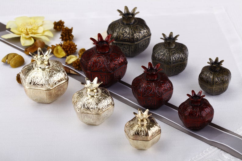 Set of 50 elegant pomegranate wedding favor boxes in various sizes, perfect for filling with treats.