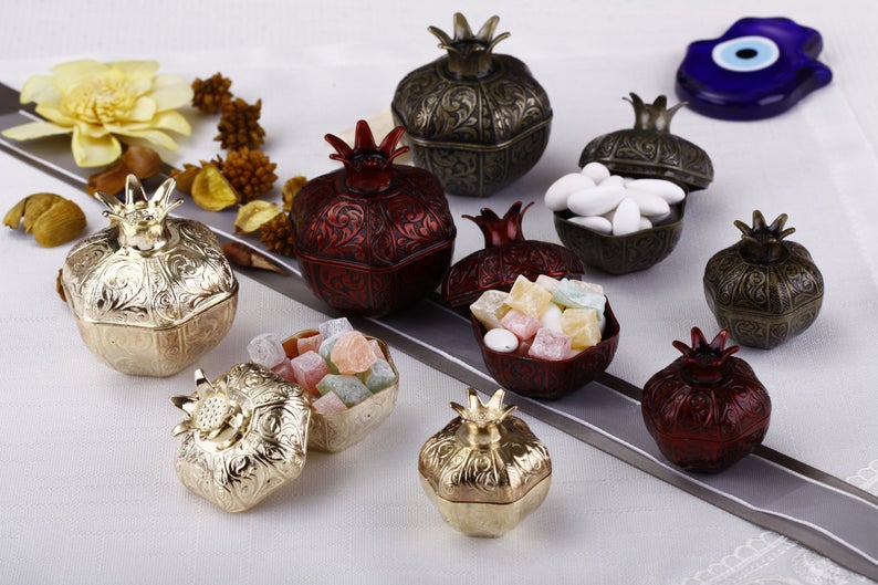 Set of 50 elegant pomegranate wedding favor boxes in various sizes, perfect for filling with treats.