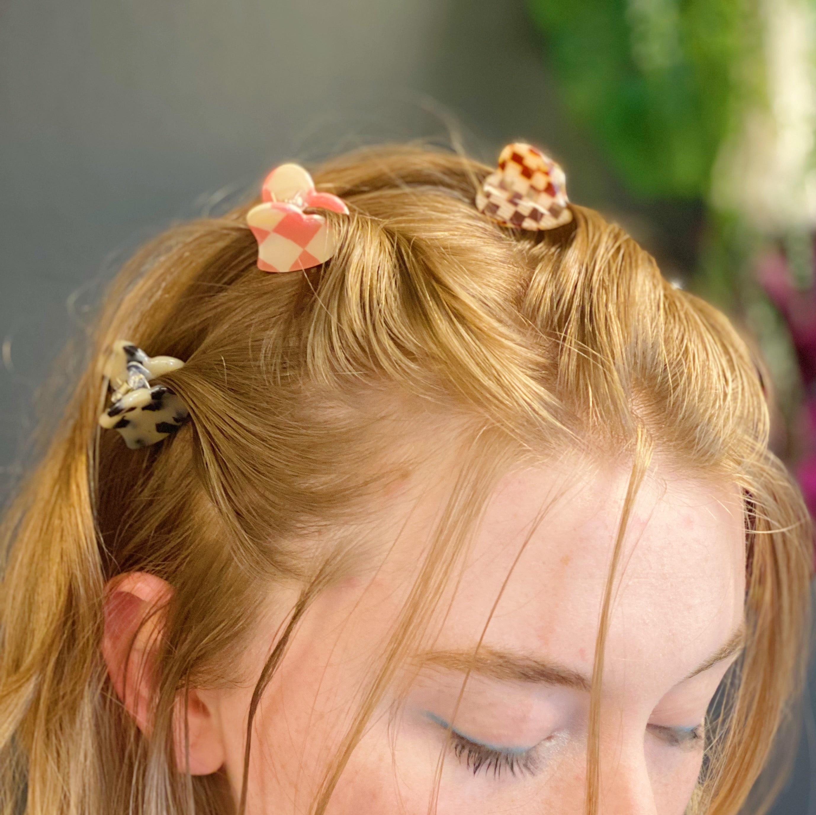 A set of five mini heart-shaped hair claws in various colors, elegantly packaged in a clear cello bag with the Ellison + Young logo.