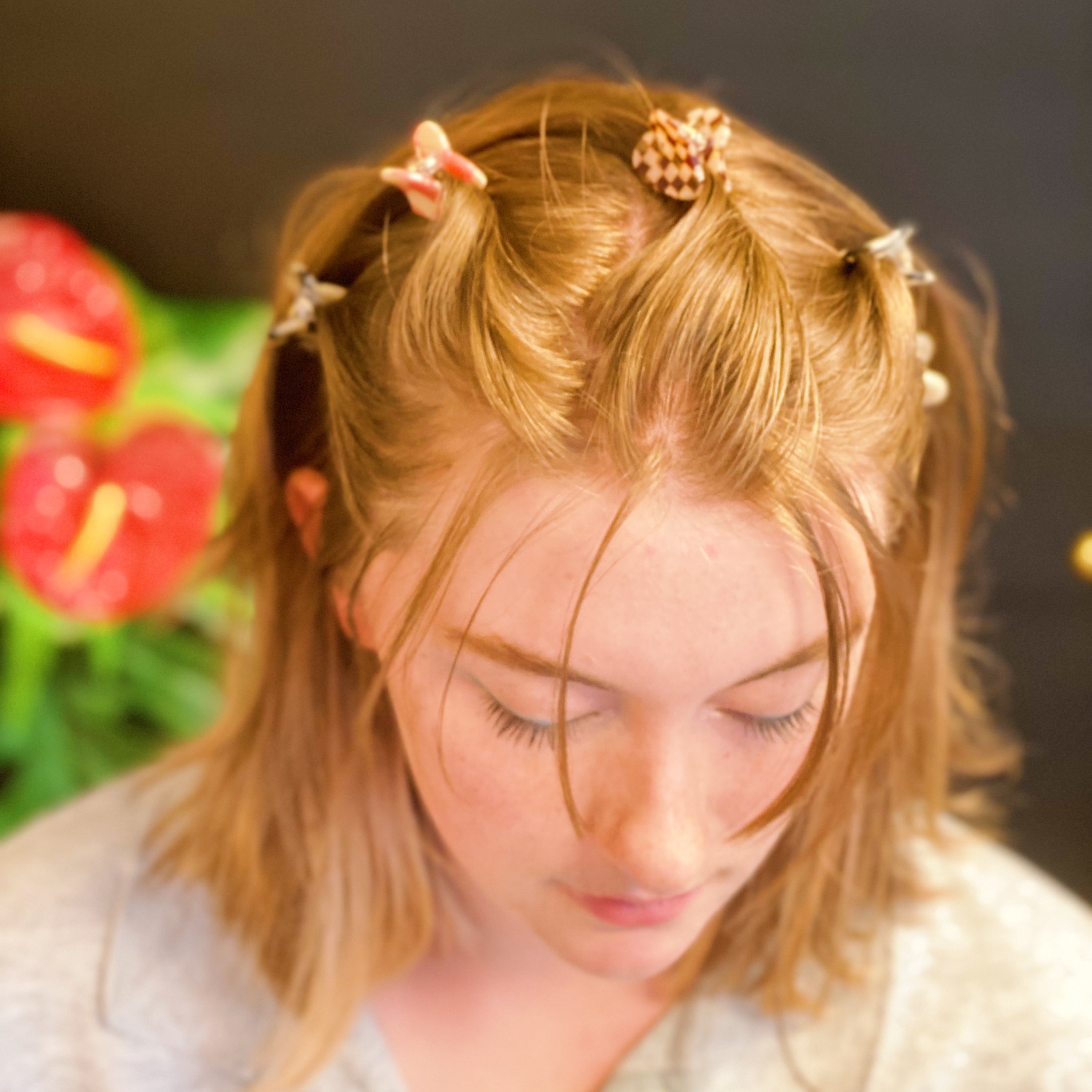 A set of five mini heart-shaped hair claws in various colors, elegantly packaged in a clear cello bag with the Ellison + Young logo.