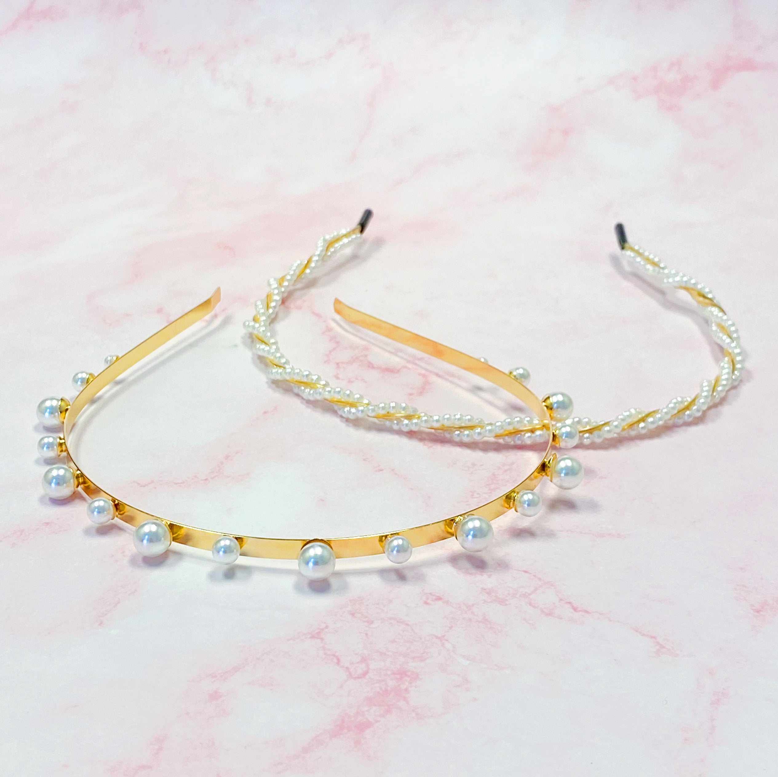 A set of two elegant pearl headbands, showcasing distinct designs and luxurious pearl detailing, perfect for any occasion.