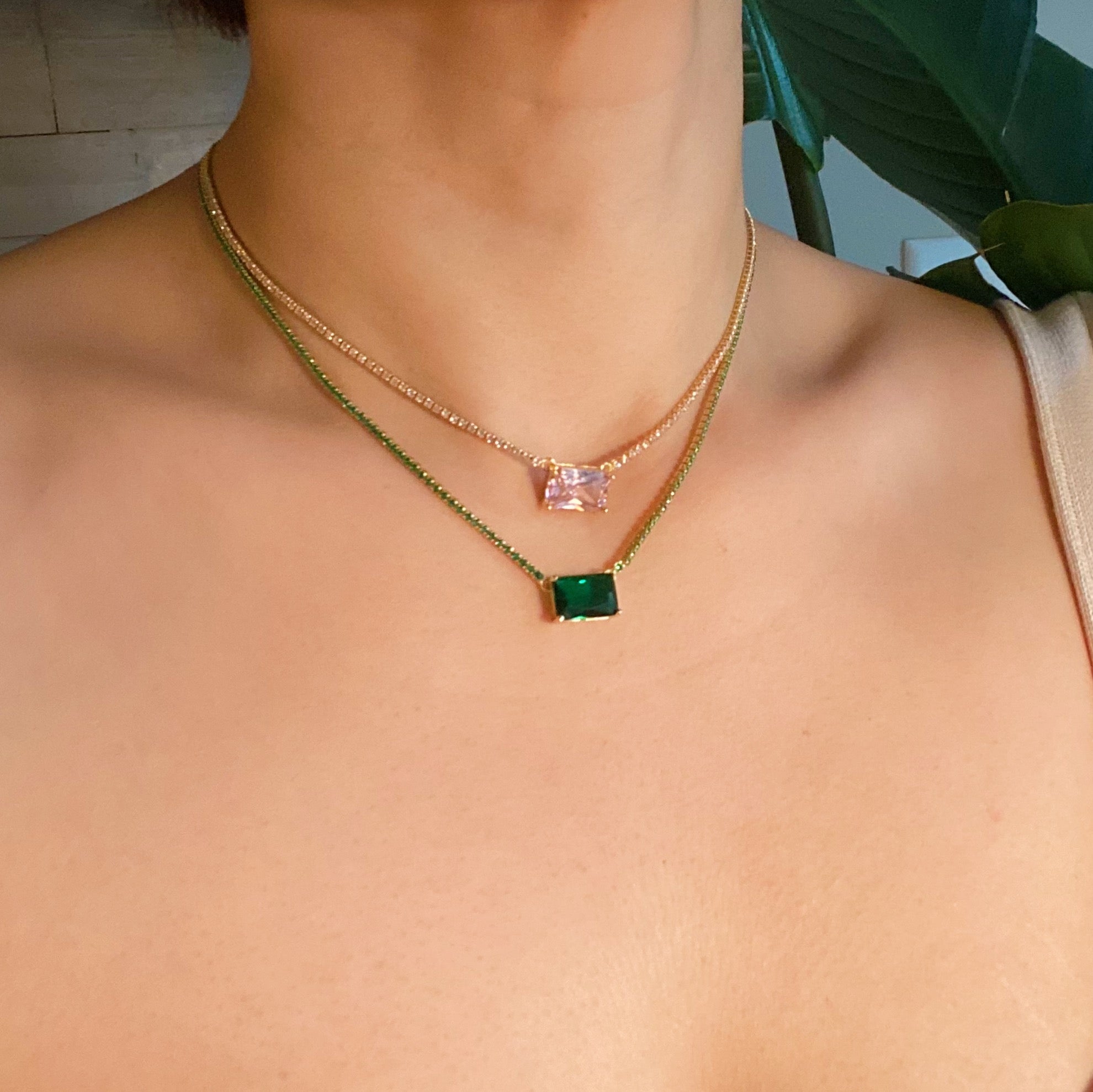 A stunning emerald cut pendant tennis necklace featuring gold-plated brass and sparkling cubic zirconia stones, perfect for elegant occasions.