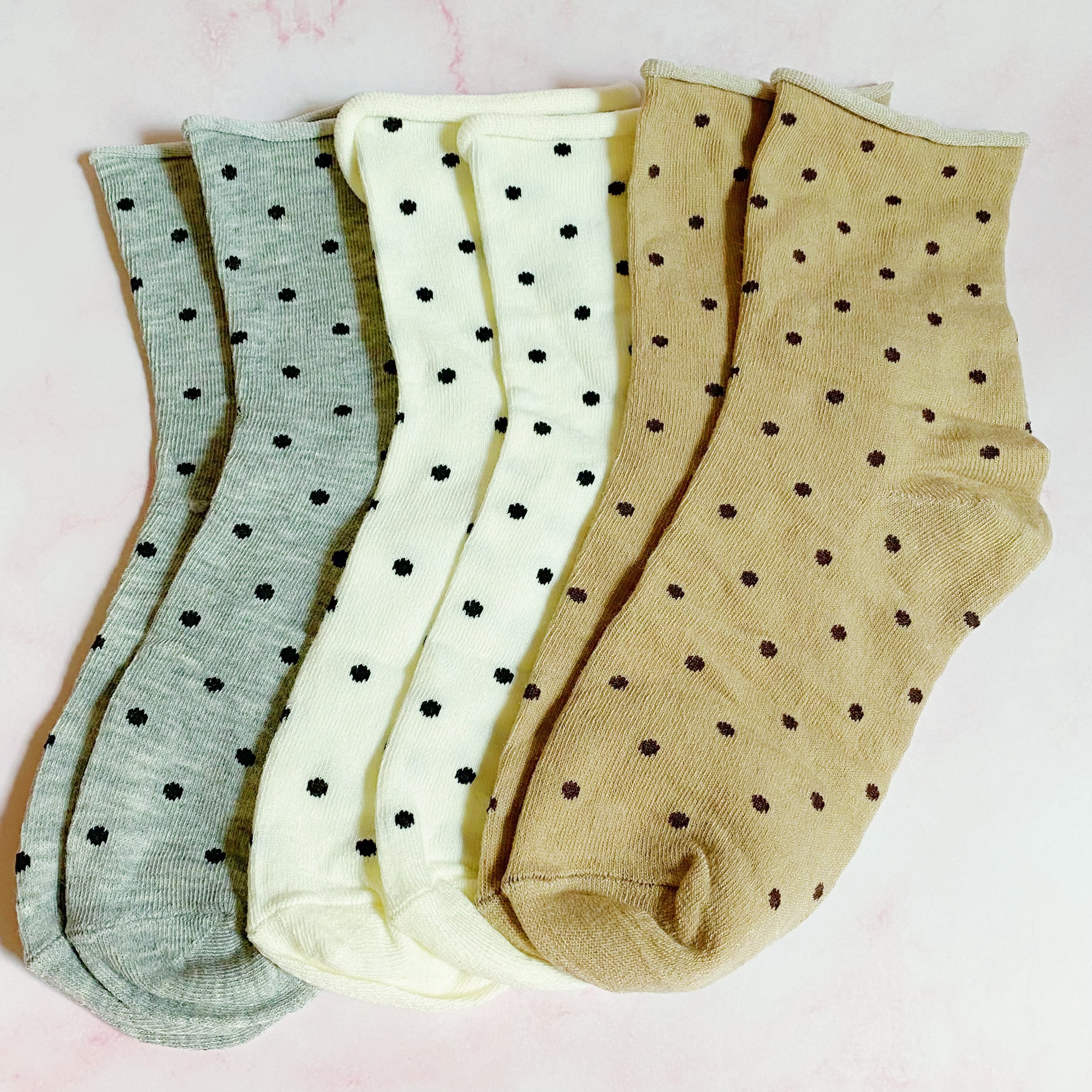 A set of three pairs of Precious Polka Dot Socks featuring colorful polka dots on a soft fabric, neatly packaged in a clear cello bag.