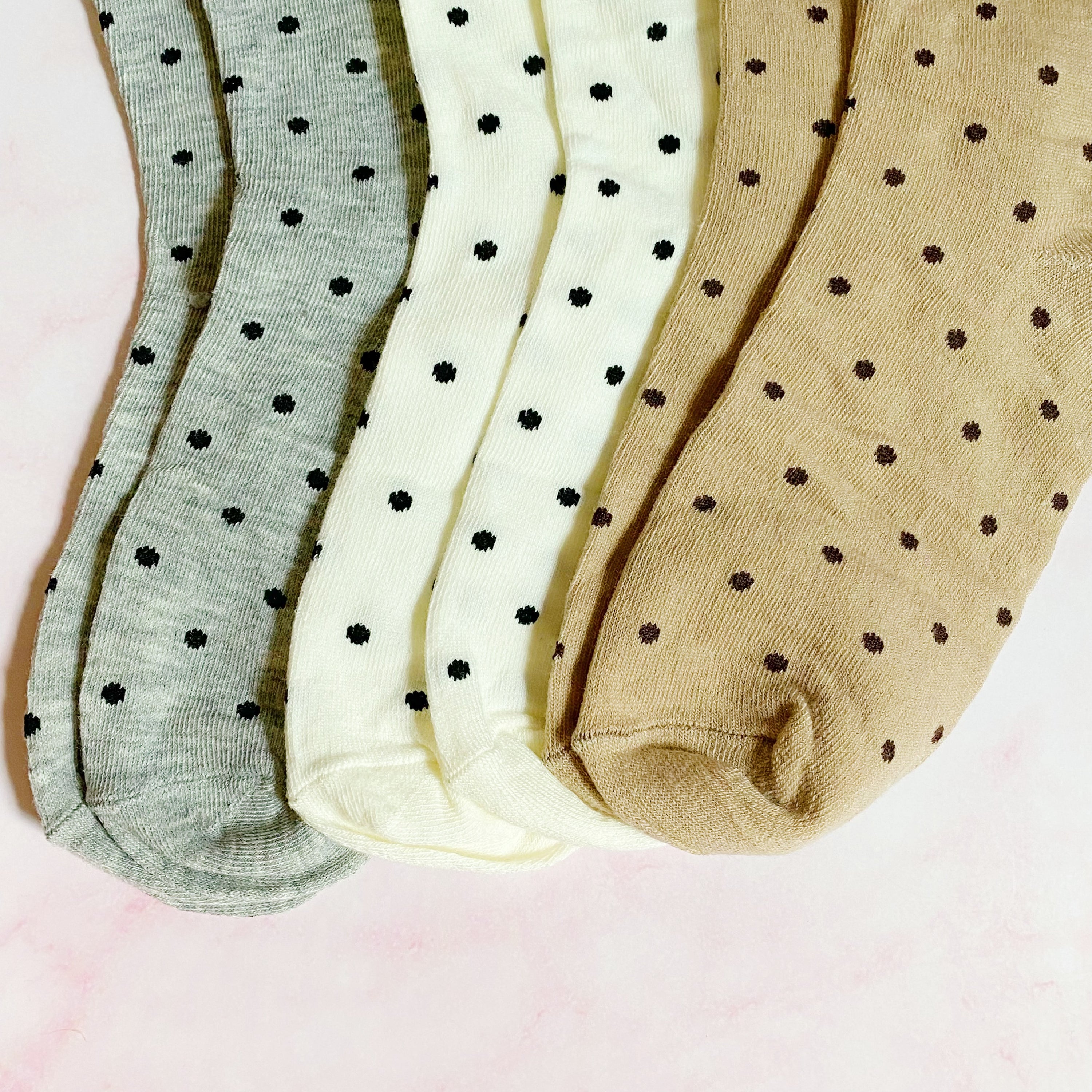 A set of three pairs of Precious Polka Dot Socks featuring colorful polka dots on a soft fabric, neatly packaged in a clear cello bag.