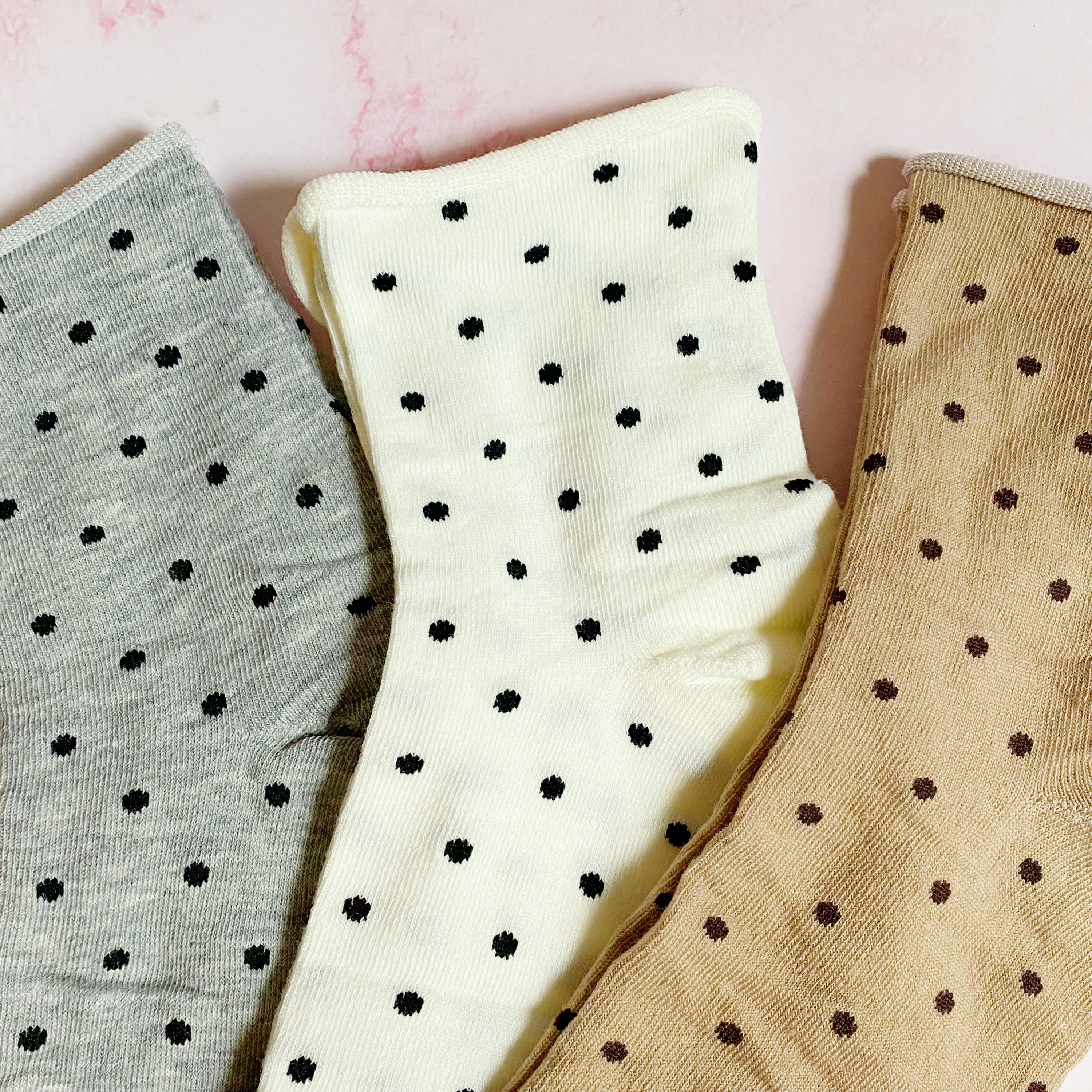 A set of three pairs of Precious Polka Dot Socks featuring colorful polka dots on a soft fabric, neatly packaged in a clear cello bag.