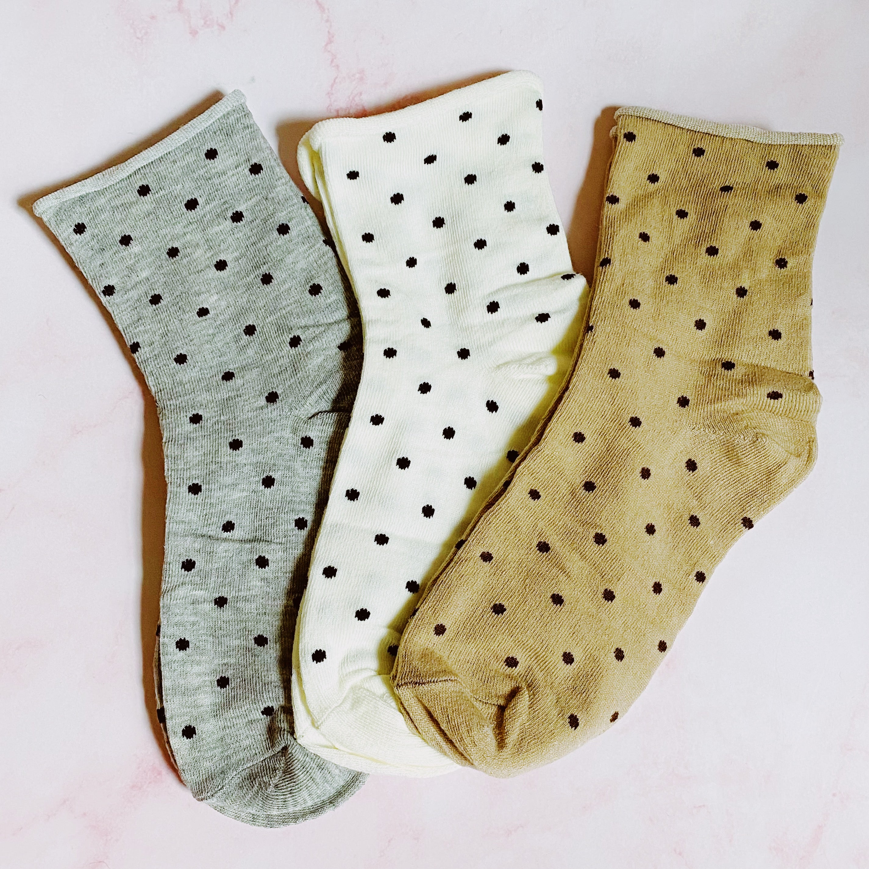 A set of three pairs of Precious Polka Dot Socks featuring colorful polka dots on a soft fabric, neatly packaged in a clear cello bag.