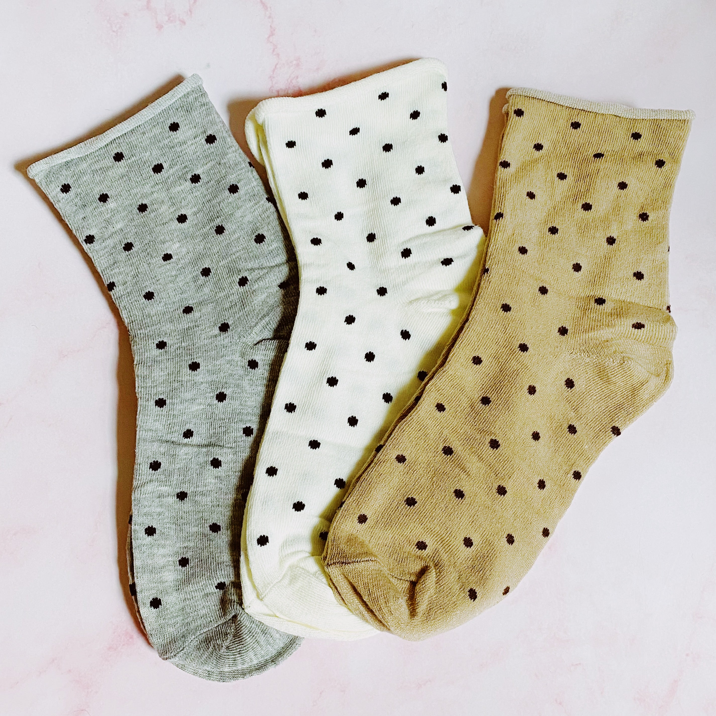 A set of three pairs of Precious Polka Dot Socks featuring colorful polka dots on a soft fabric, neatly packaged in a clear cello bag.