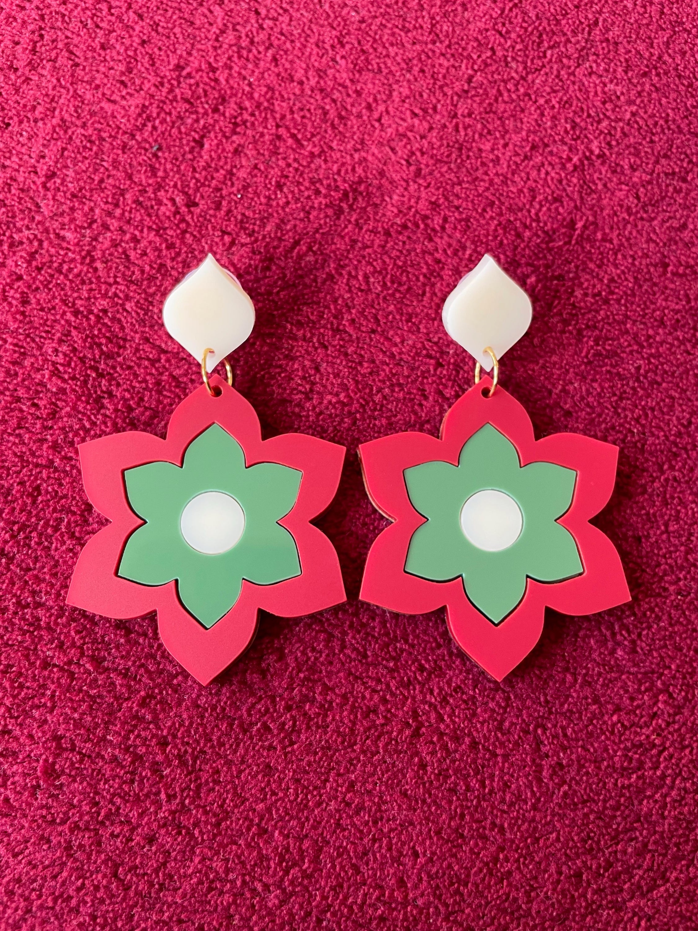 A pair of Prudence Earrings and a matching brooch, showcasing vibrant colors and intricate laser cut acrylic designs inspired by 1960s fashion.