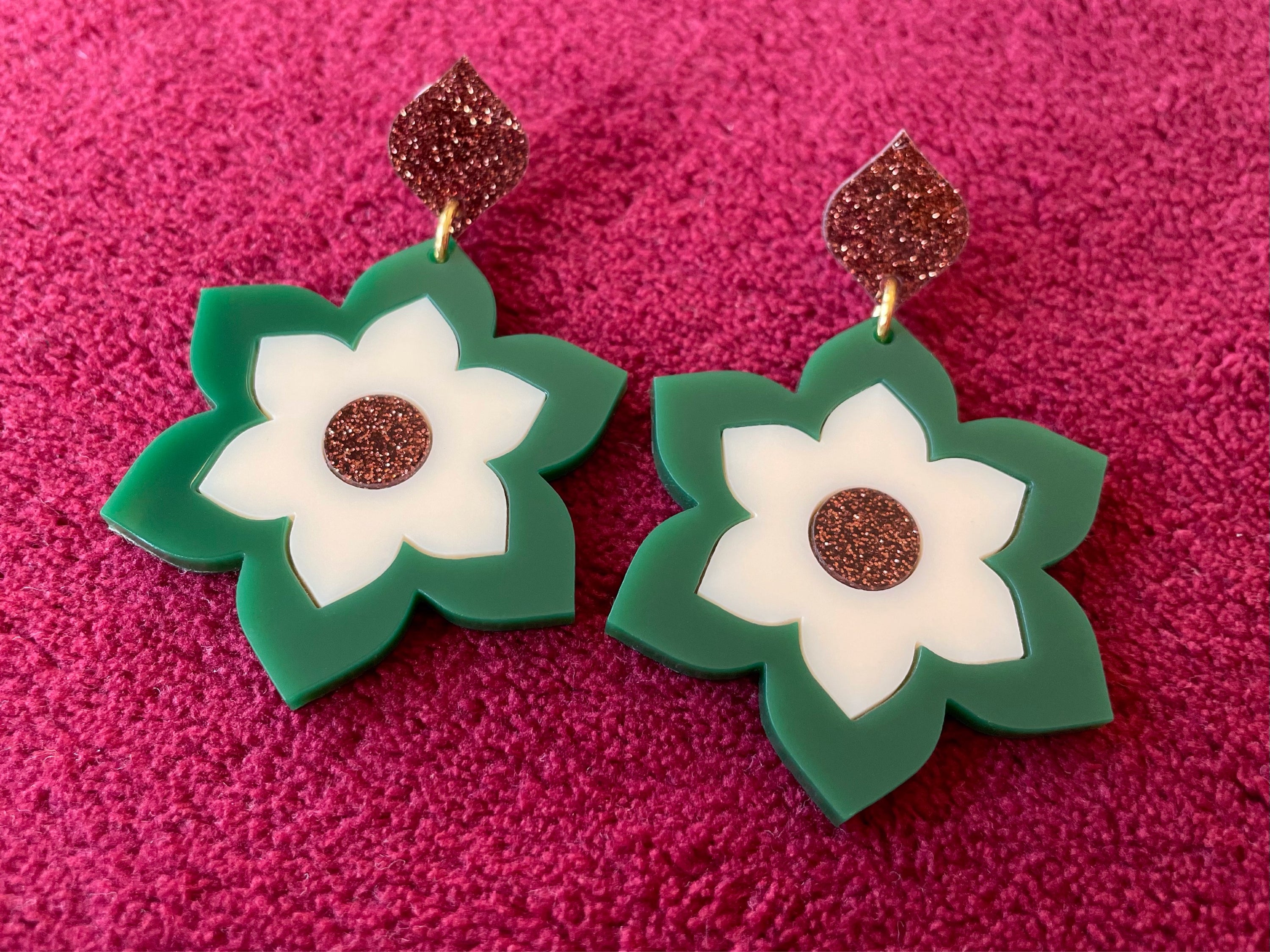 A pair of Prudence Earrings and a matching brooch, showcasing vibrant colors and intricate laser cut acrylic designs inspired by 1960s fashion.