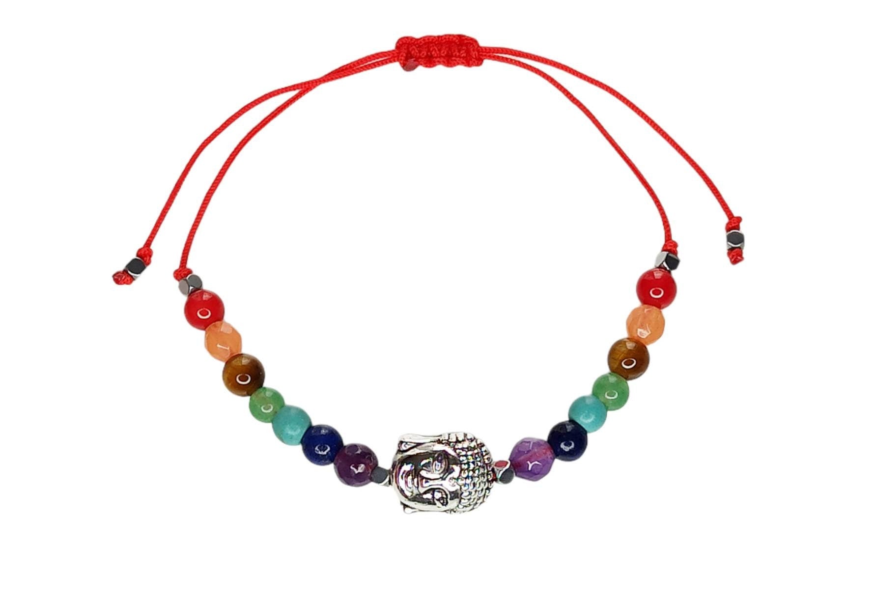 Pulsera de 7 chakras con dije de Buda en plata tibetana, ajustable y hecha a mano, presentada en una tarjeta decorativa.