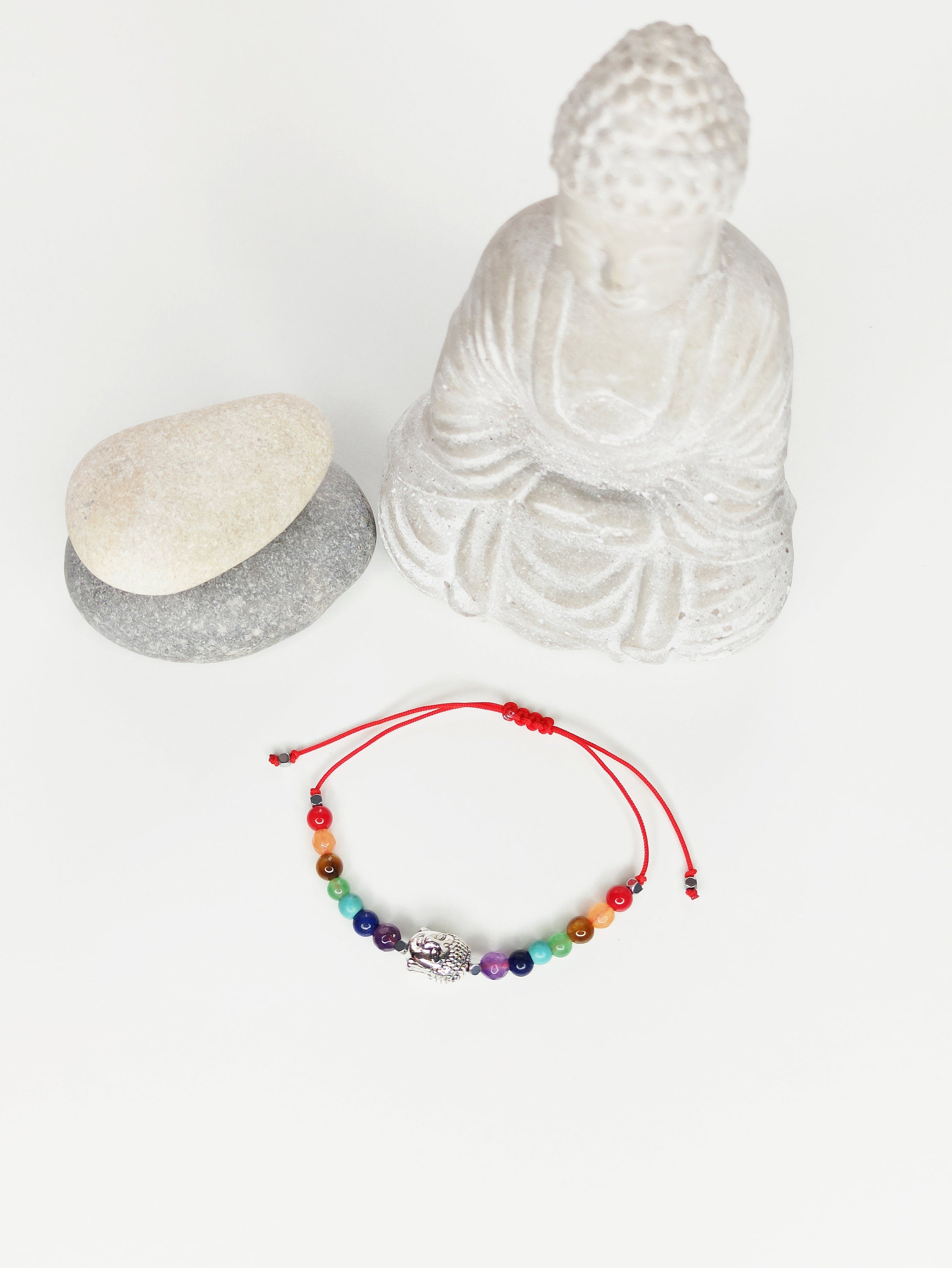 Pulsera de 7 chakras con dije de Buda en plata tibetana, ajustable y hecha a mano, presentada en una tarjeta decorativa.