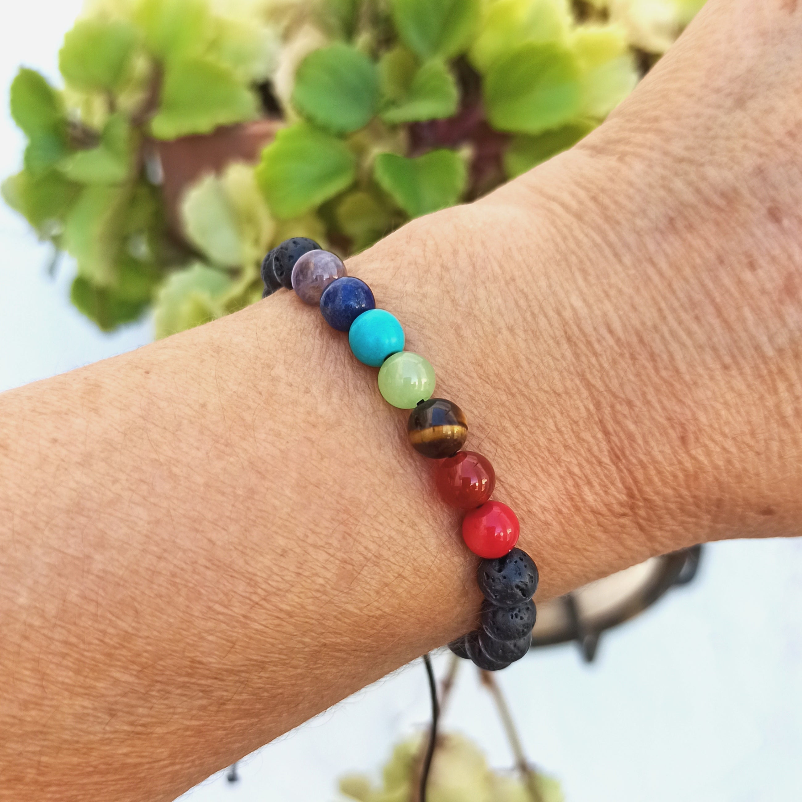 Pulsera ajustable de 7 chakras con piedras volcánicas negras, hecha a mano, ideal para equilibrar energías y lucir un estilo único.