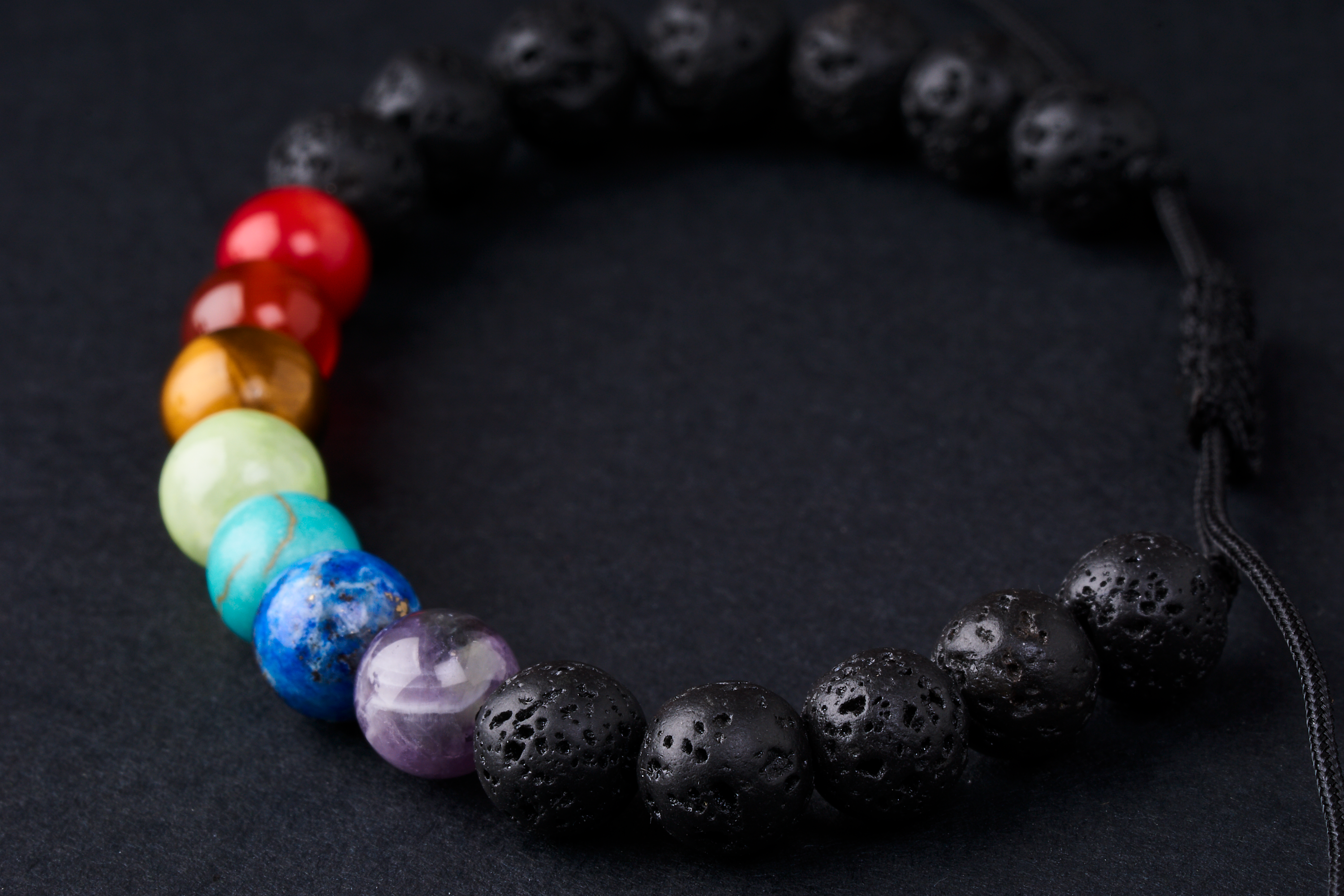 Pulsera ajustable de 7 chakras con piedras volcánicas negras, hecha a mano, ideal para equilibrar energías y lucir un estilo único.