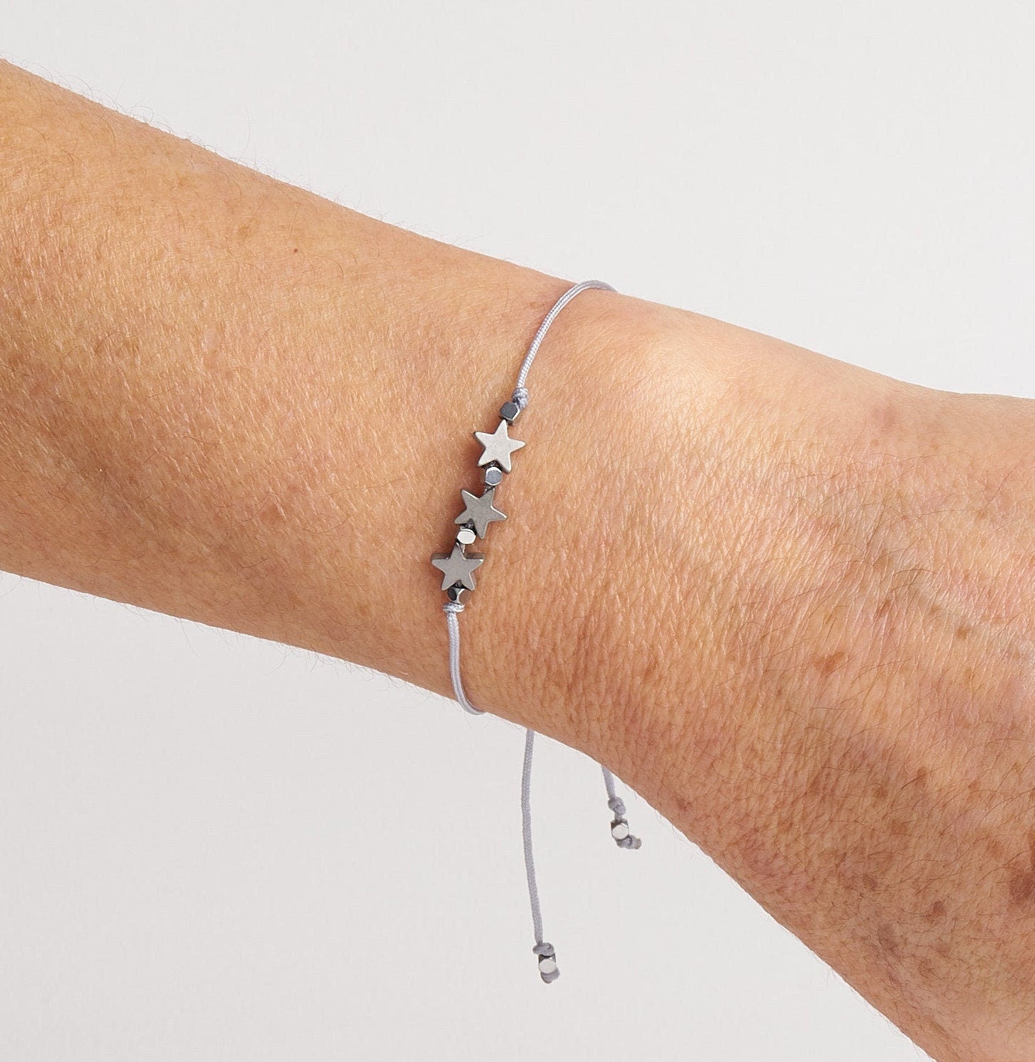 Pulsera ajustable con estrellas de hematitas en cordón, ideal como regalo de amistad.