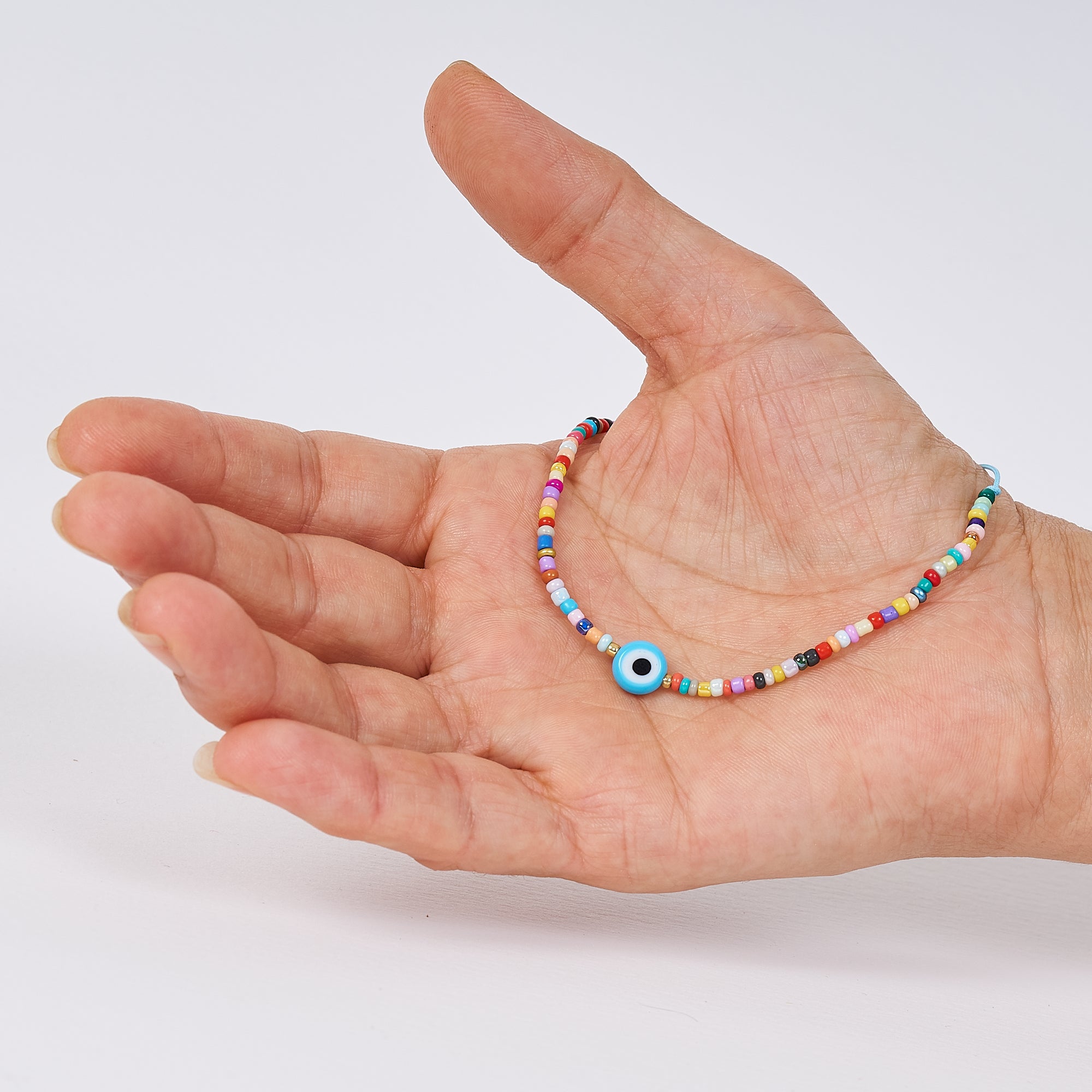 Pulsera de abalorios con ojo turco, hecha a mano con cuentas checas multicolores y un ojo Nazar, símbolo de protección.