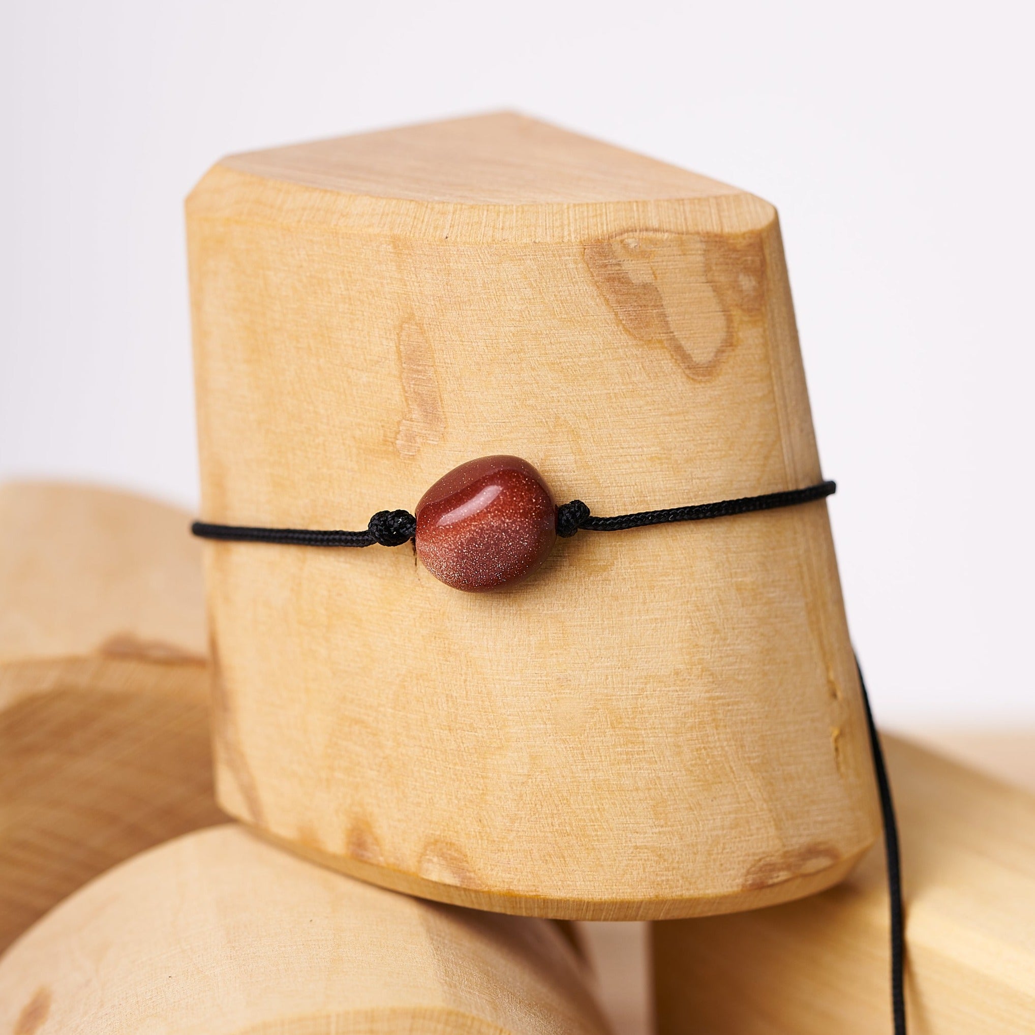 Pulsera de piedra lluvia de oro en solitario, con diseño minimalista y cordón ajustable, ideal para un look diario.