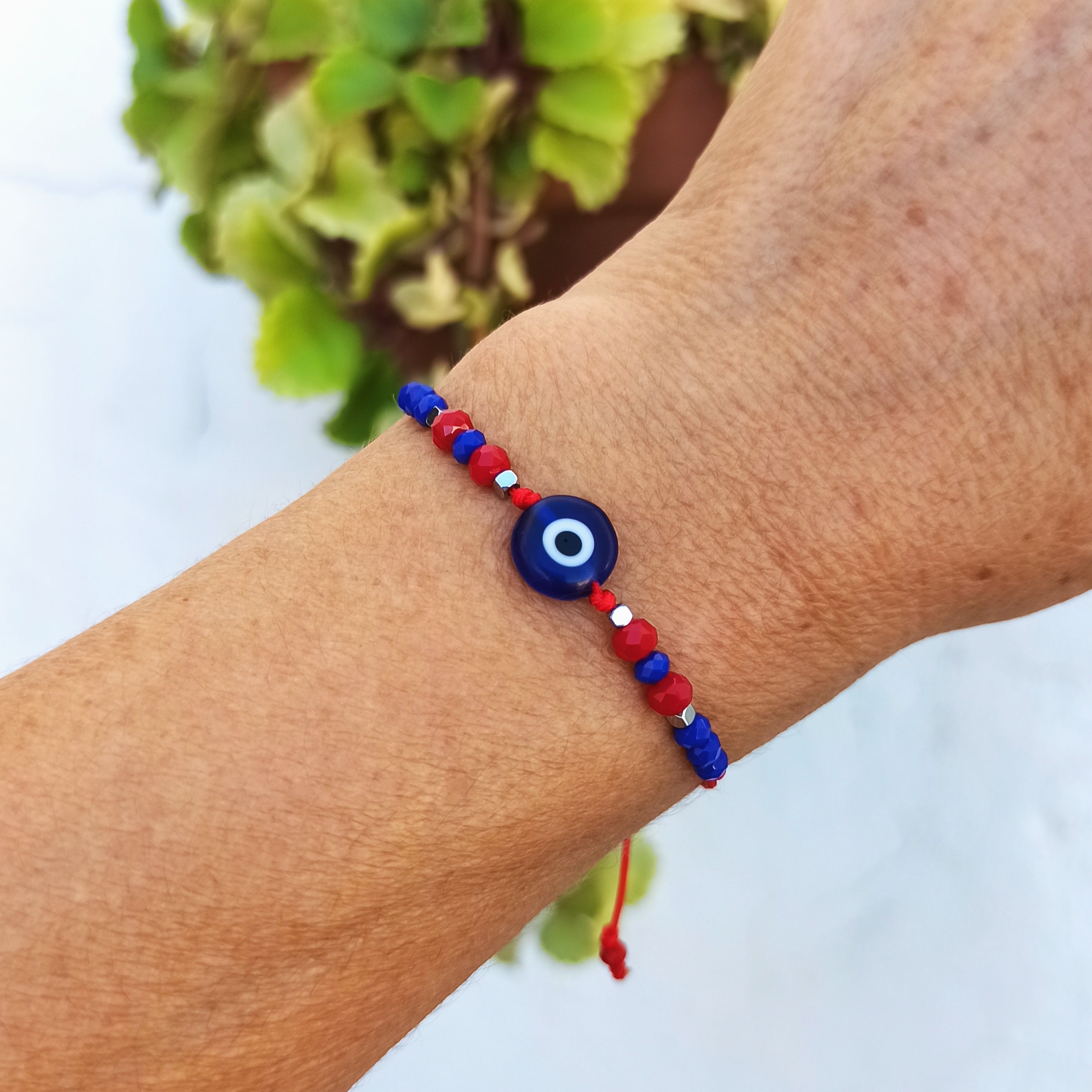 Pulsera de protección con ojo turco, cristales checos en rojo y azul, y cordón rojo ajustable, ideal para atraer buena suerte.