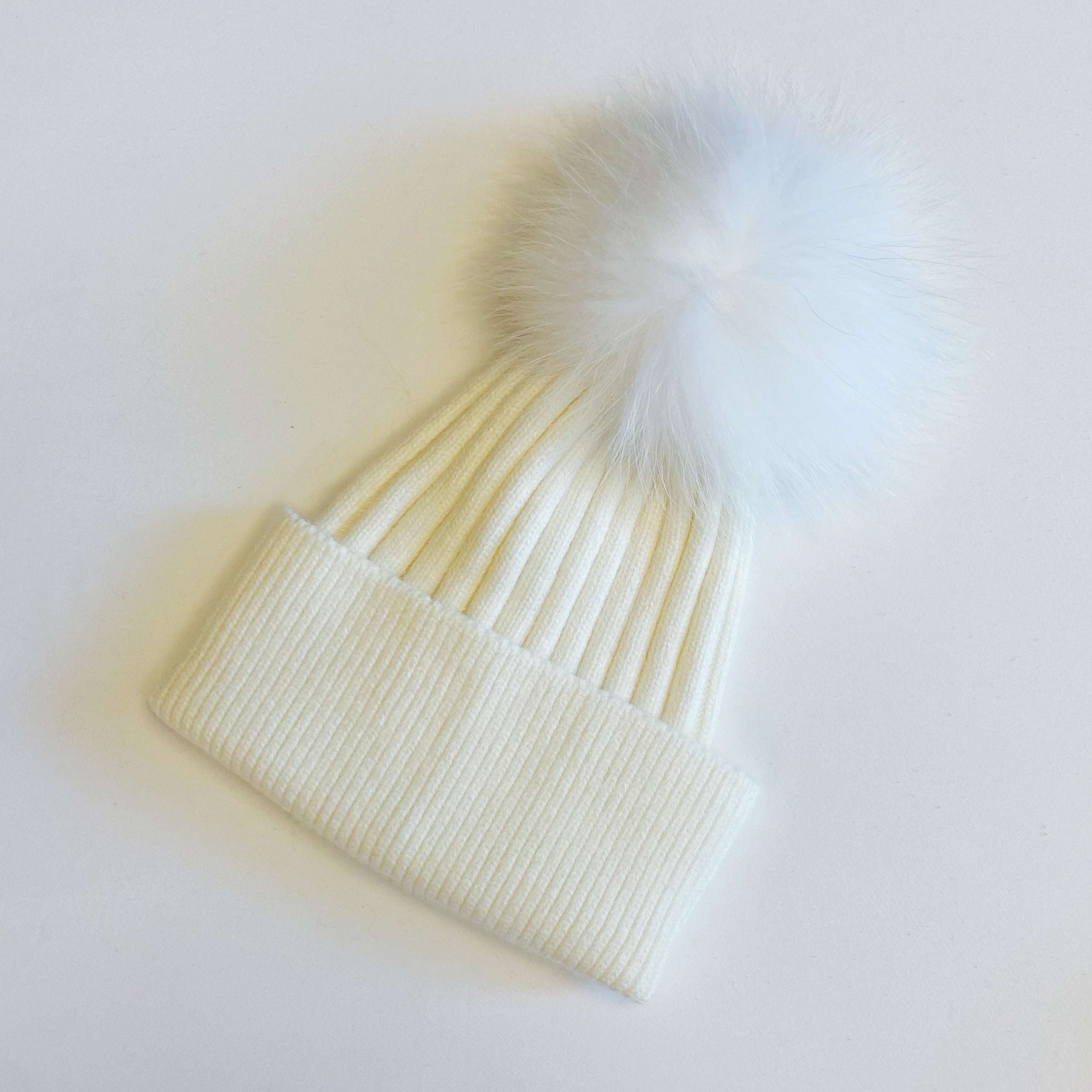 Luxurious Pure Angora Genuine Fur Luxe Beanie with raccoon fur pom pom, showcasing a soft knit design in a stylish fold-over style.