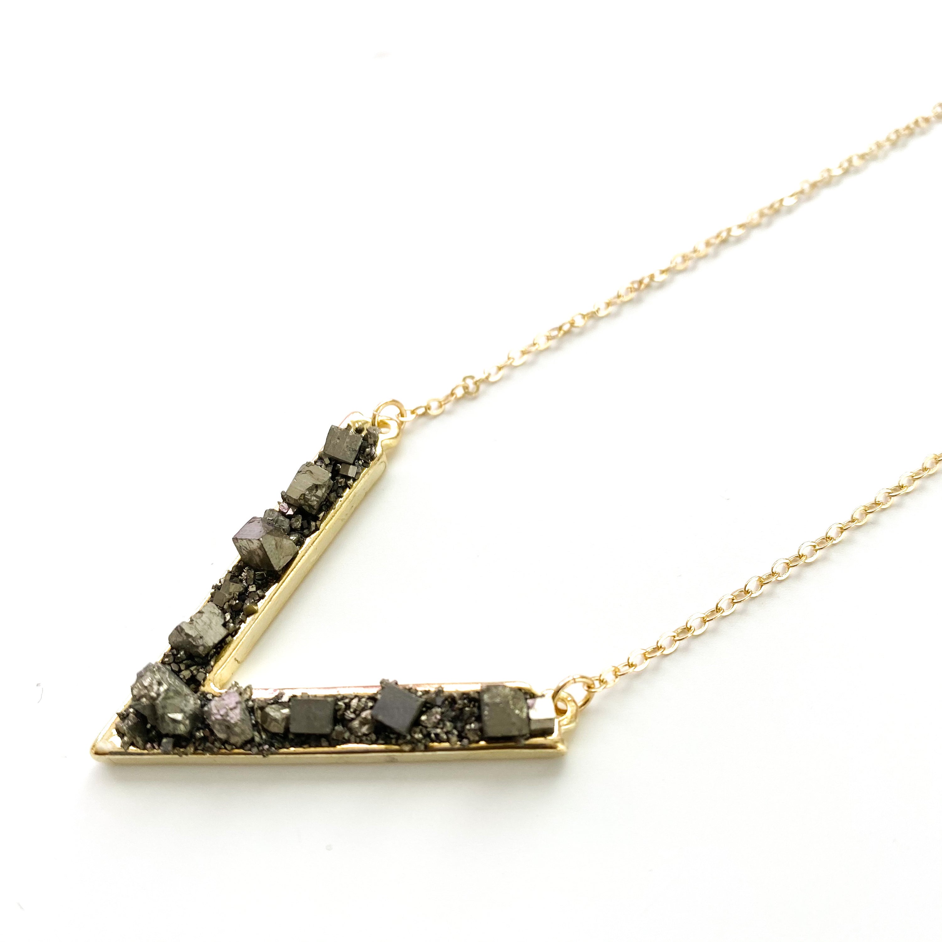 A handmade Purely Pyrite Necklace featuring pyrite nuggets on an 18K gold plated link chain, elegantly designed in a 'V' shape.