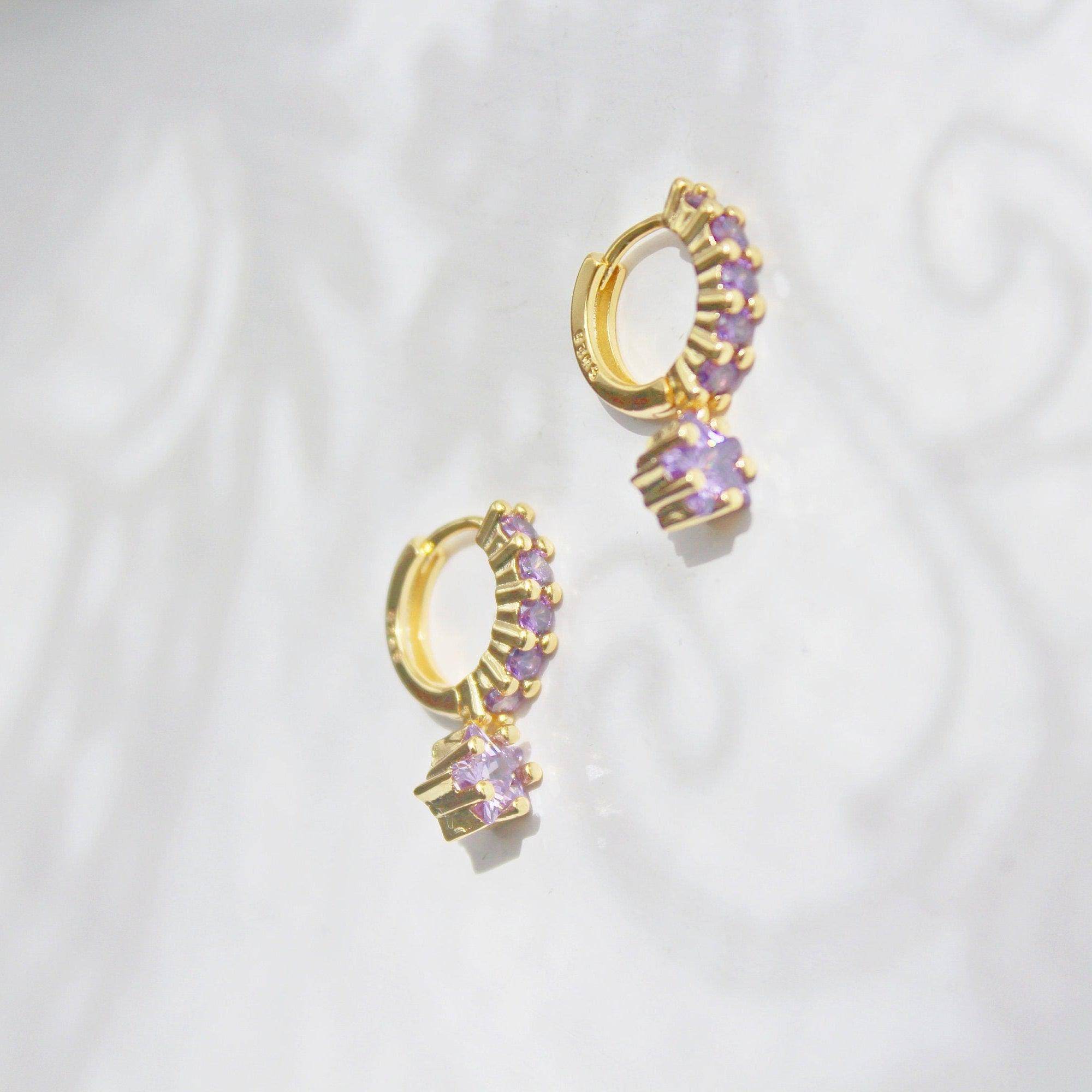 Elegant purple crystal star drop earrings on gold hoops, crafted from sterling silver.