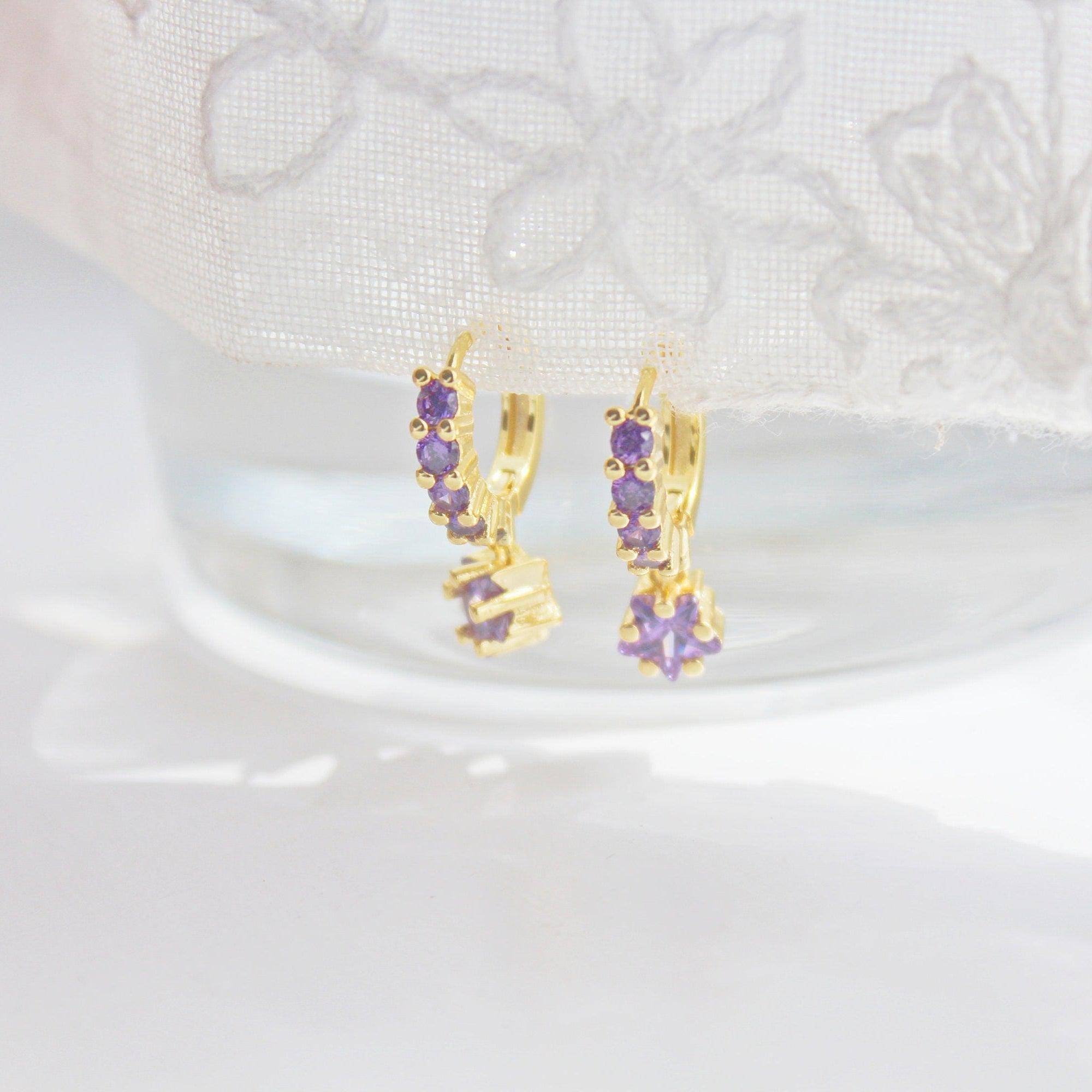 Elegant purple crystal star drop earrings on gold hoops, crafted from sterling silver.