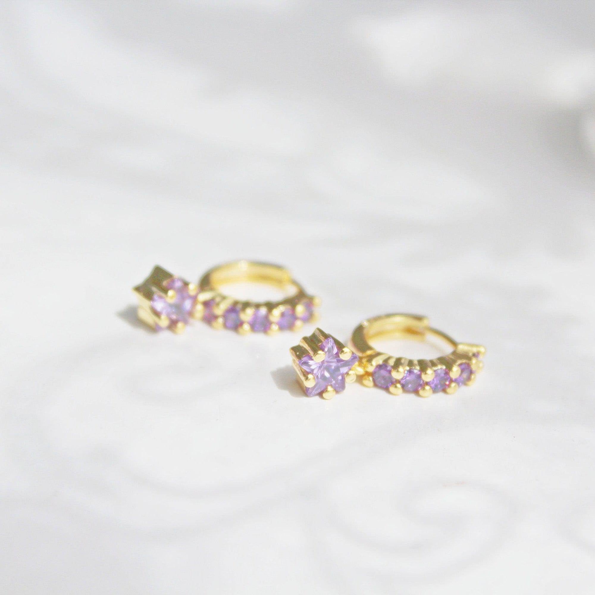 Elegant purple crystal star drop earrings on gold hoops, crafted from sterling silver.