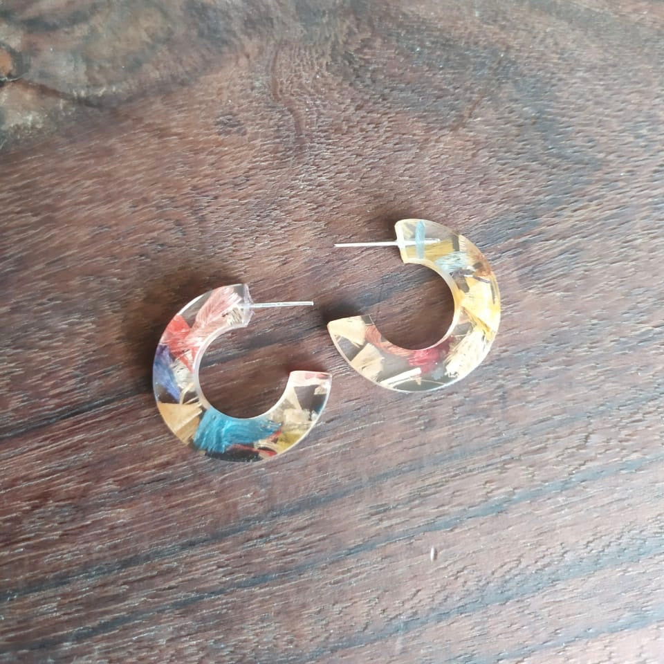 Quartilla Eco Friendly Resin Hoop Earrings made from recycled skateboard wood shavings and plant resin, showcasing vibrant colors and unique patterns.