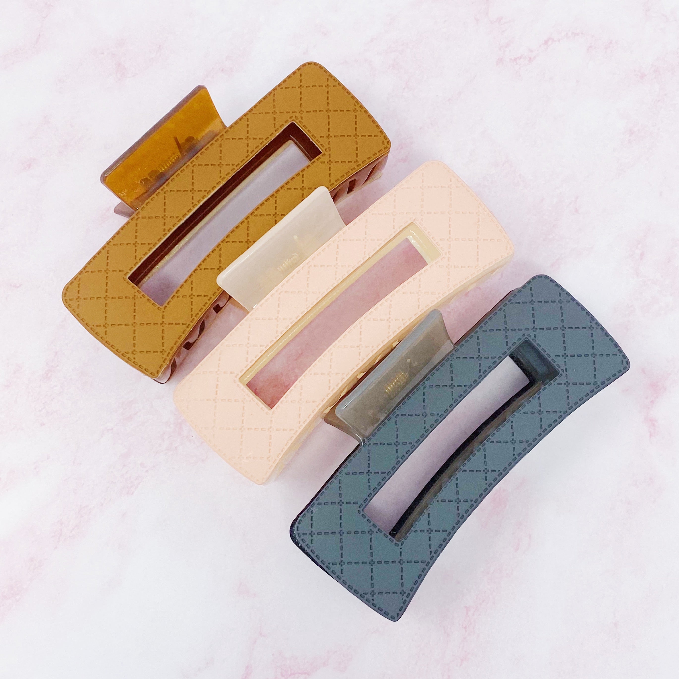 A stylish set of three quilted hair claws in vibrant colors, perfect for securing hair in place with elegance.