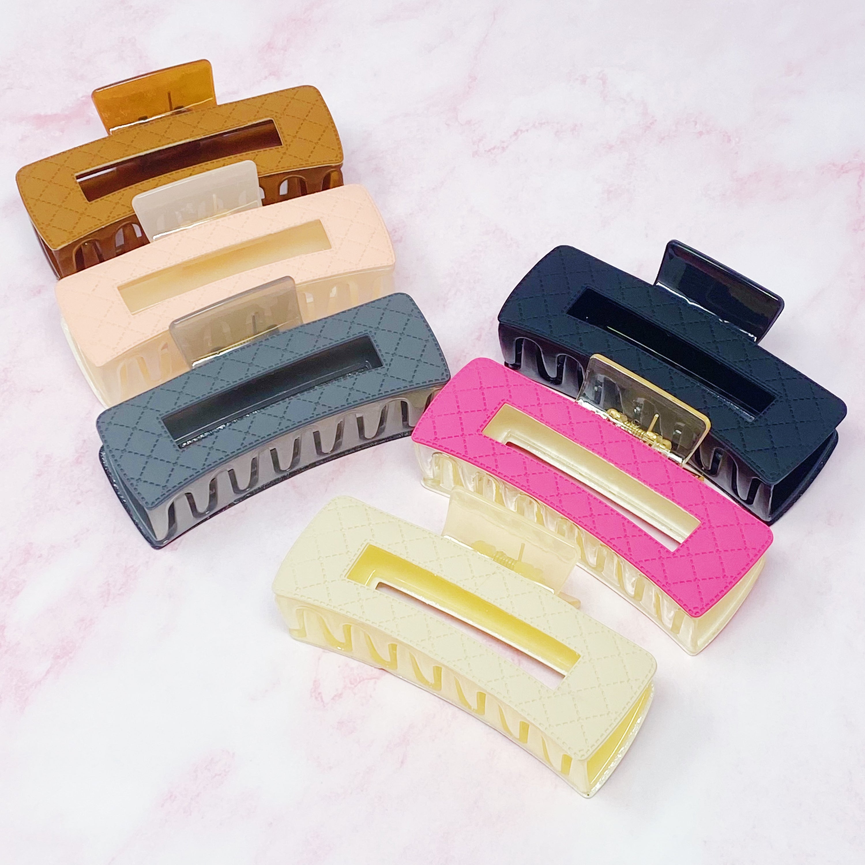 A stylish set of three quilted hair claws in vibrant colors, perfect for securing hair in place with elegance.