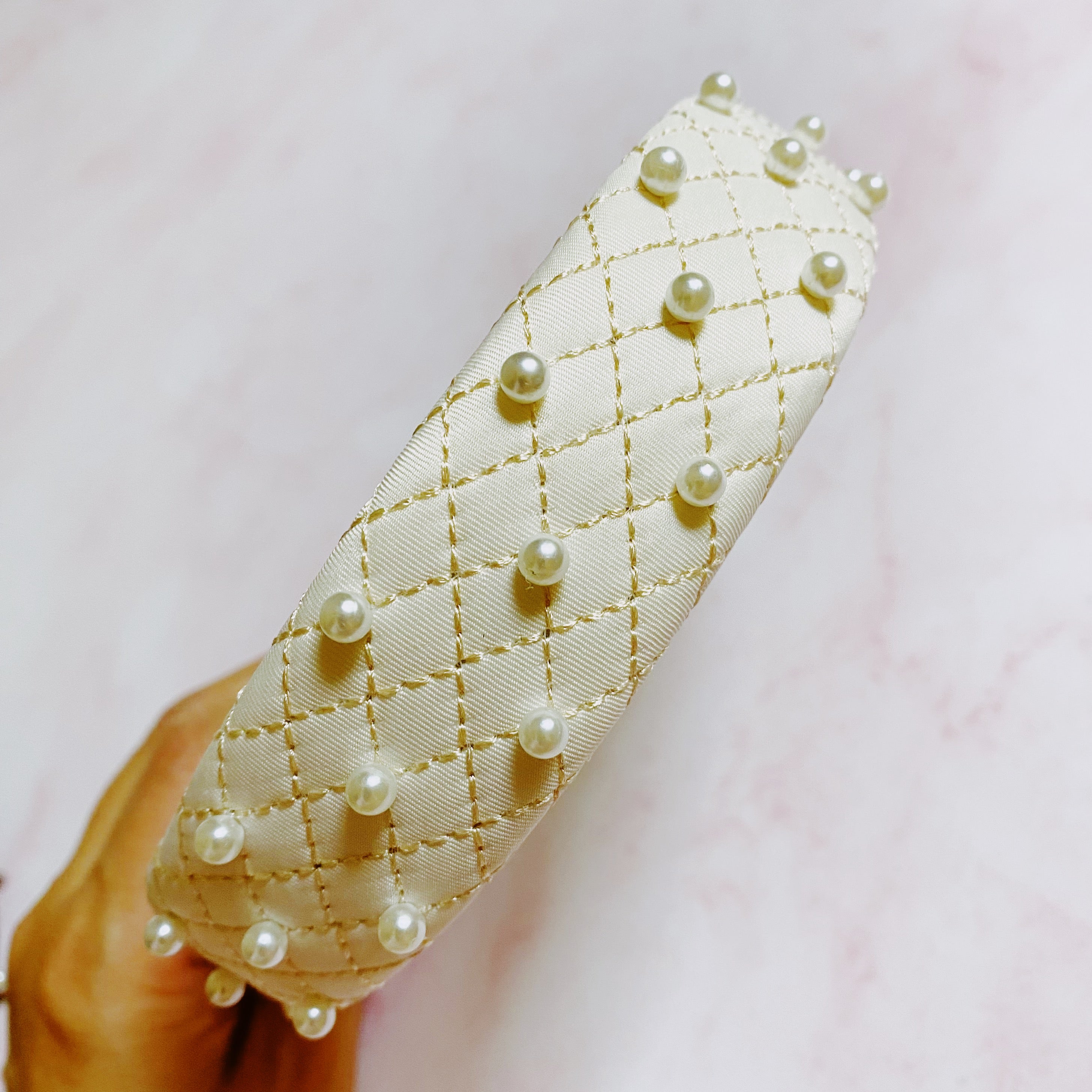 Quilted Elegance Pearl Headband featuring quilted fabric and hand-nailed small pearls, perfect for elegant styling.