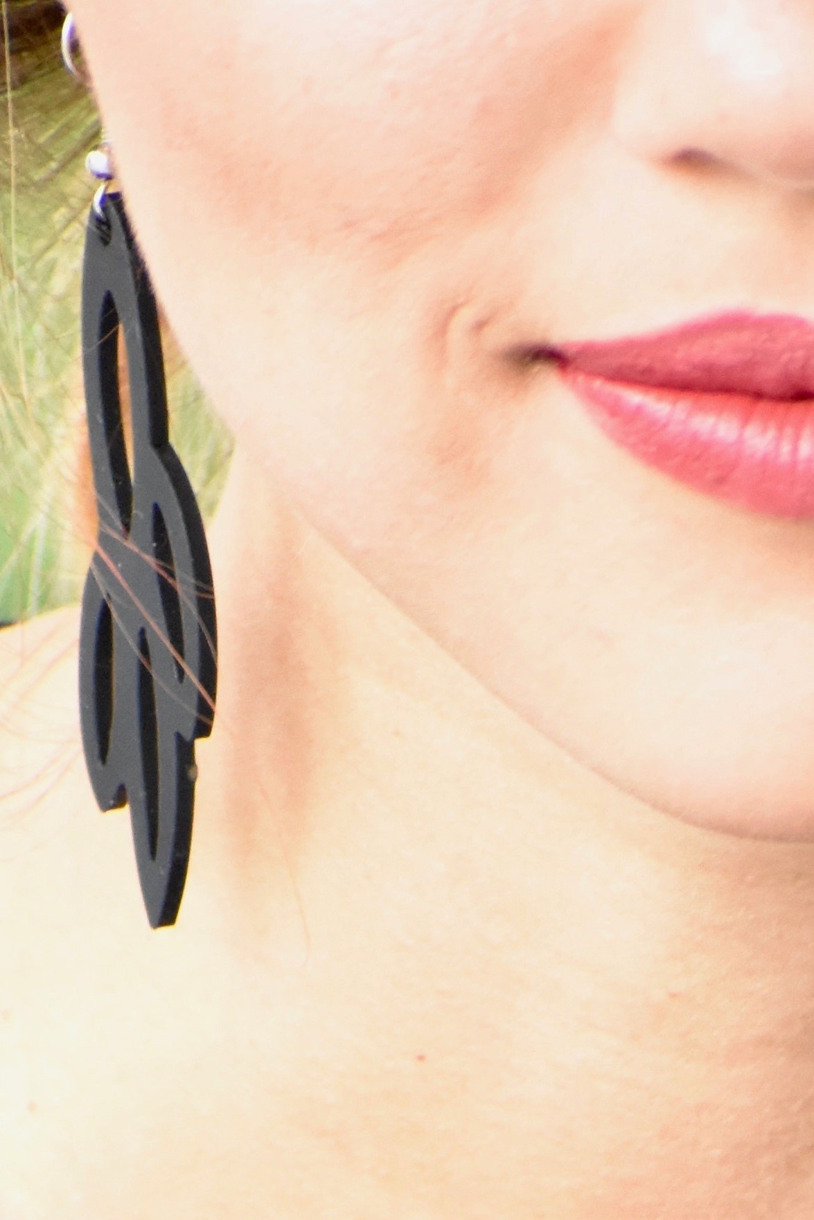 A pair of elegant Radiant Earrings displayed in a velvet pouch, showcasing their unique design and lightweight features.