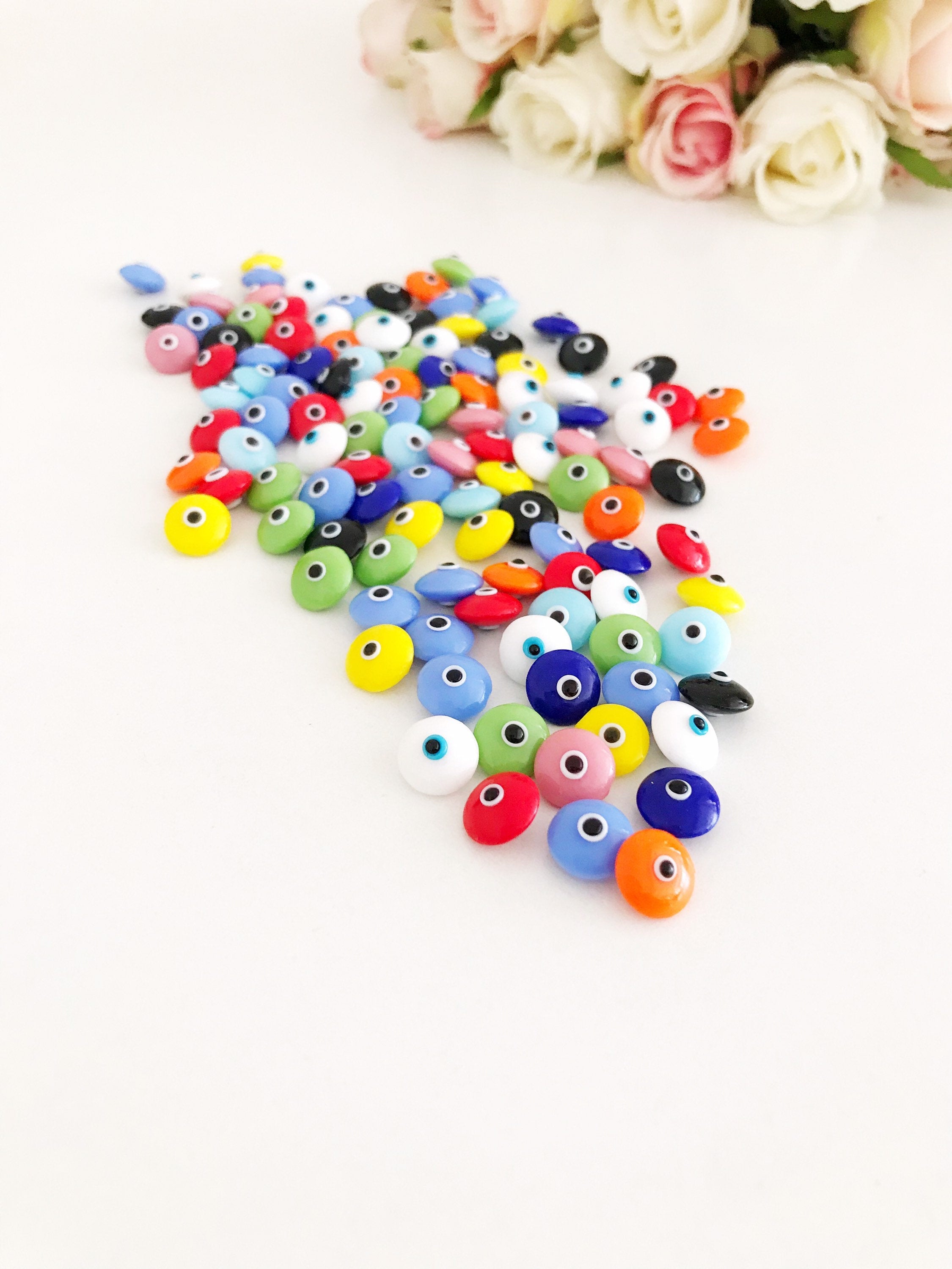 A collection of colorful Rainbow Evil Eye Cabochons, showcasing various designs and colors, perfect for DIY jewelry making.