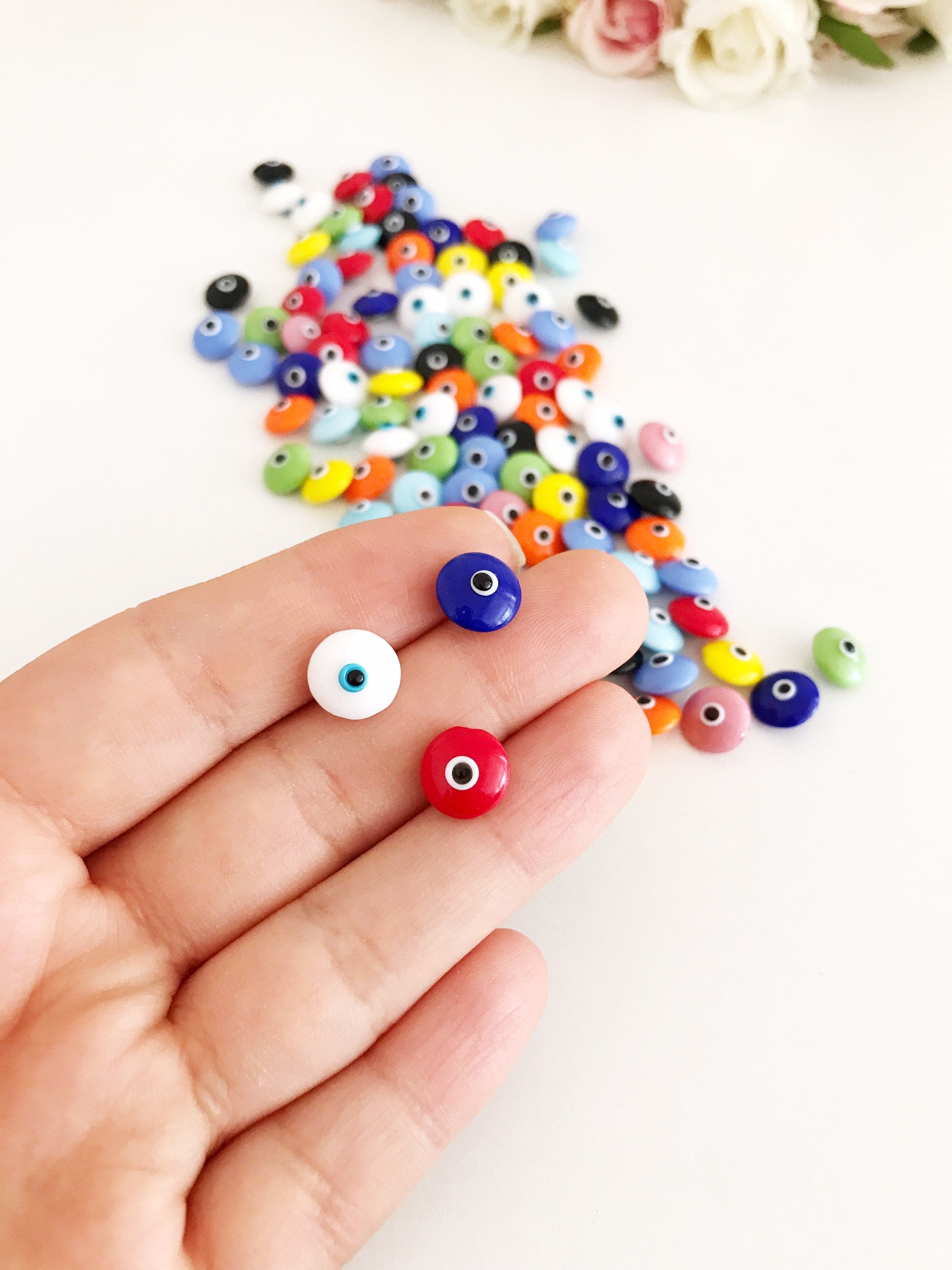 A collection of colorful Rainbow Evil Eye Cabochons, showcasing various designs and colors, perfect for DIY jewelry making.