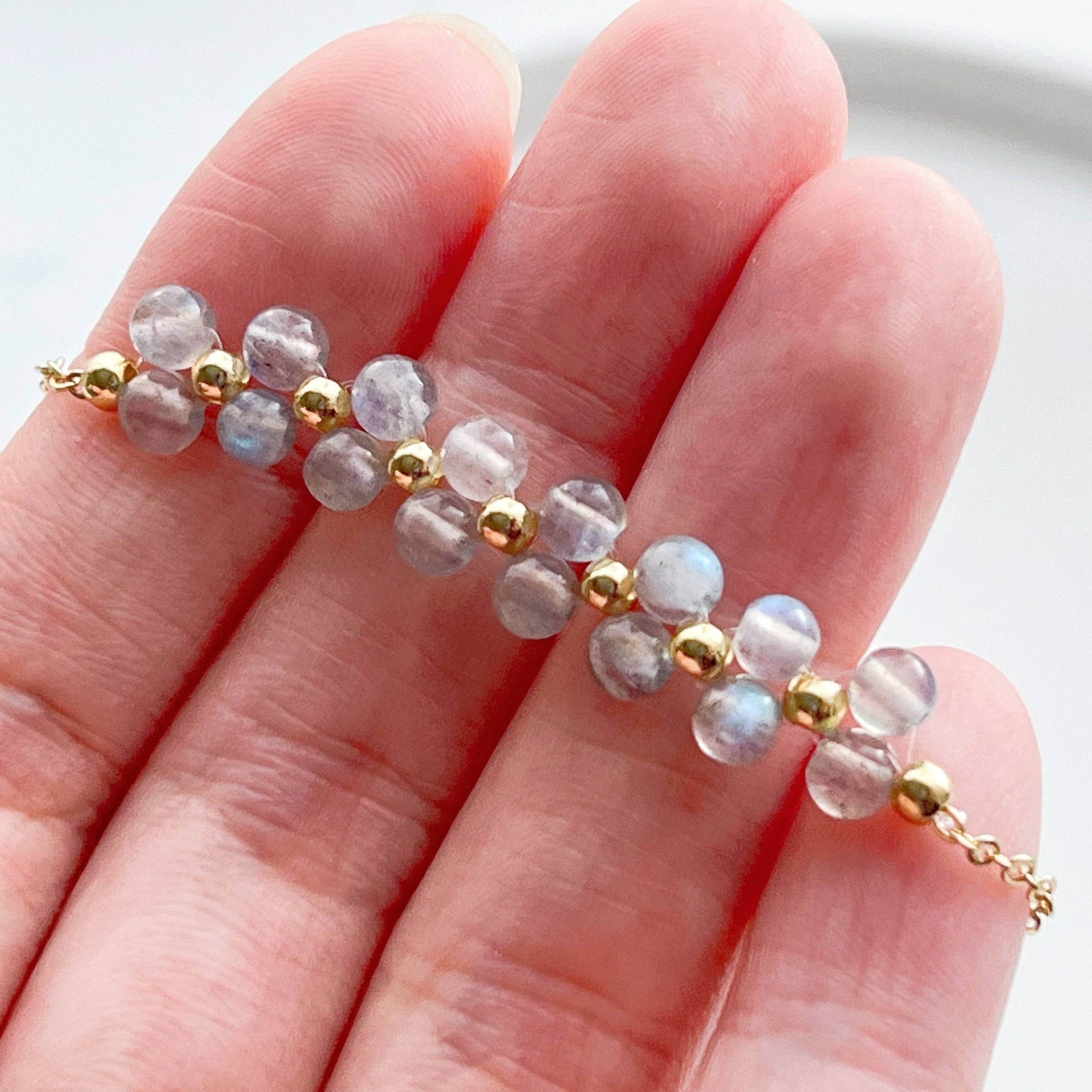 A stunning Rainbow Moonstone Bracelet featuring natural moonstone beads and gold-tone accents, elegantly displayed on a soft background.