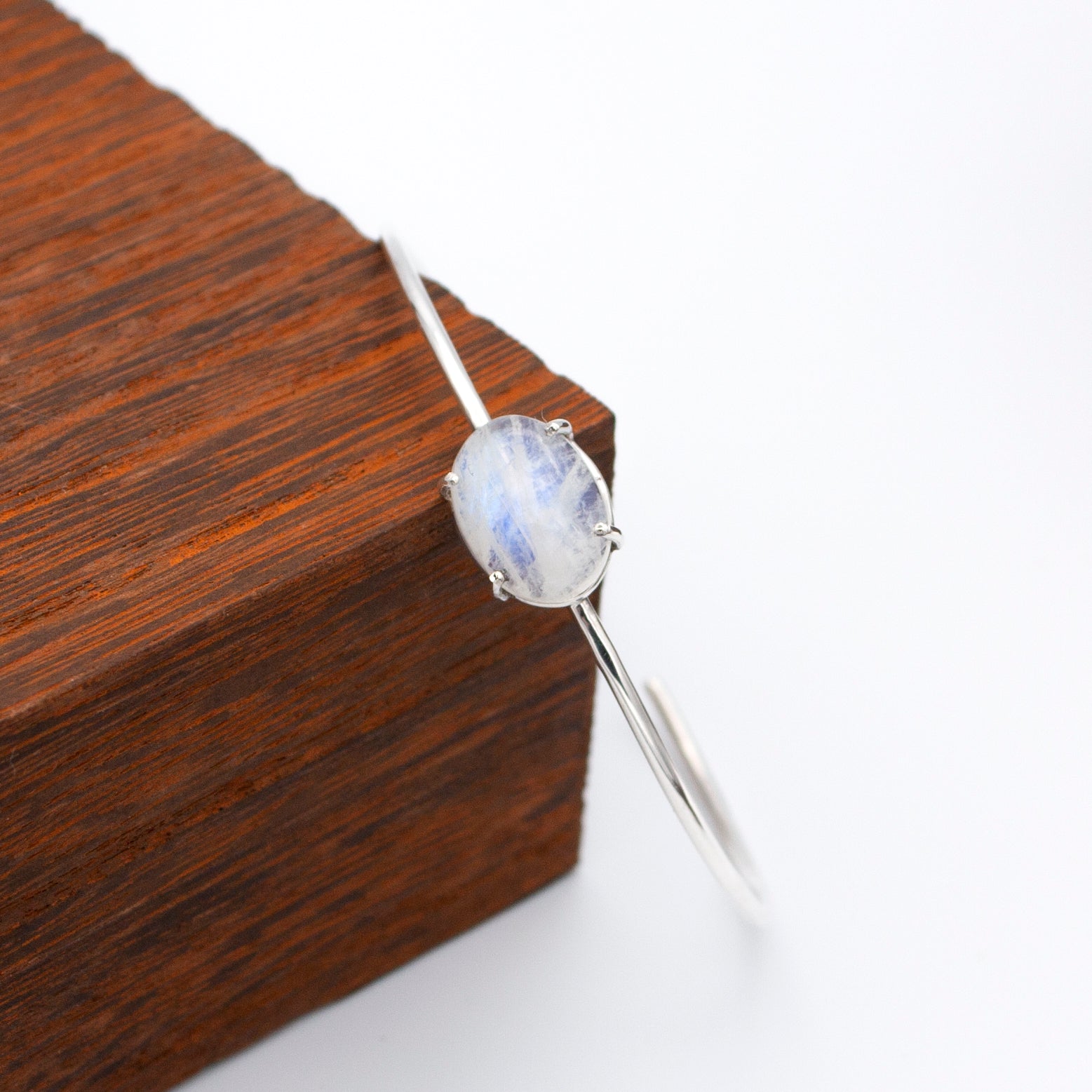 A beautiful Rainbow Moonstone Sterling Silver Cuff Bracelet showcasing a natural 10x12mm gemstone set in .925 sterling silver.