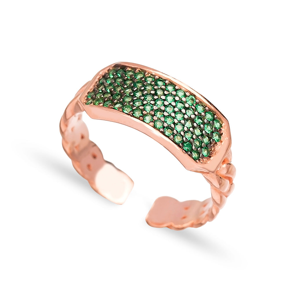 RAINE Ring featuring a stiff chain link design in yellow gold plating with green cubic zirconias, showcasing its adjustable fit and contemporary style.