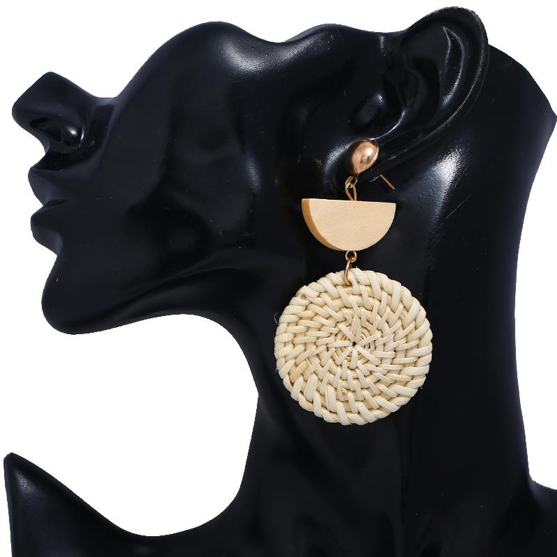 A pair of elegant Rattan Earrings featuring organic wooden straw weave and wood bead embellishments, perfect for eco-conscious fashion lovers.