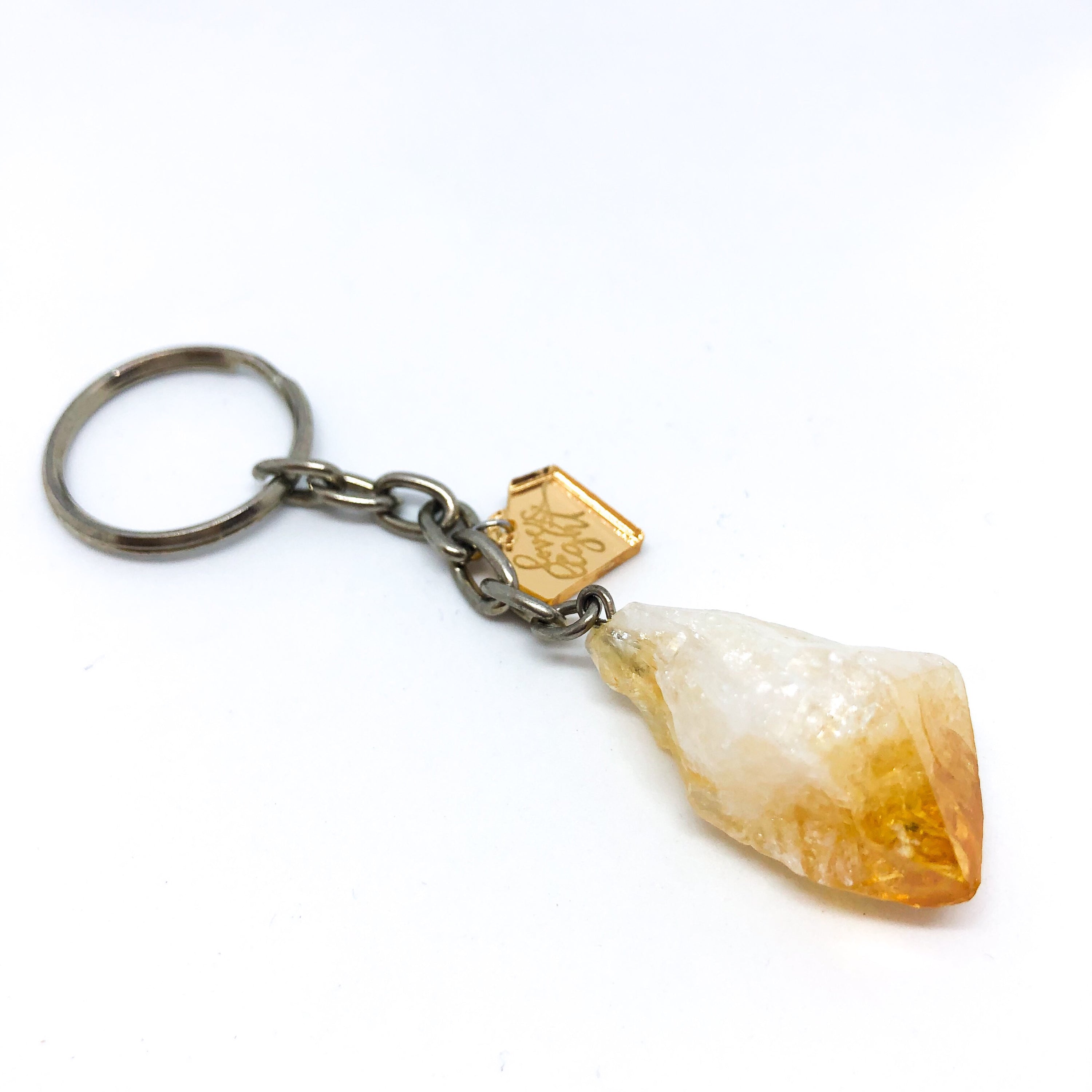 A collection of unique Raw Crystal Keychains featuring natural raw cut crystals in various shapes and sizes, accented with a silver LLJ charm.