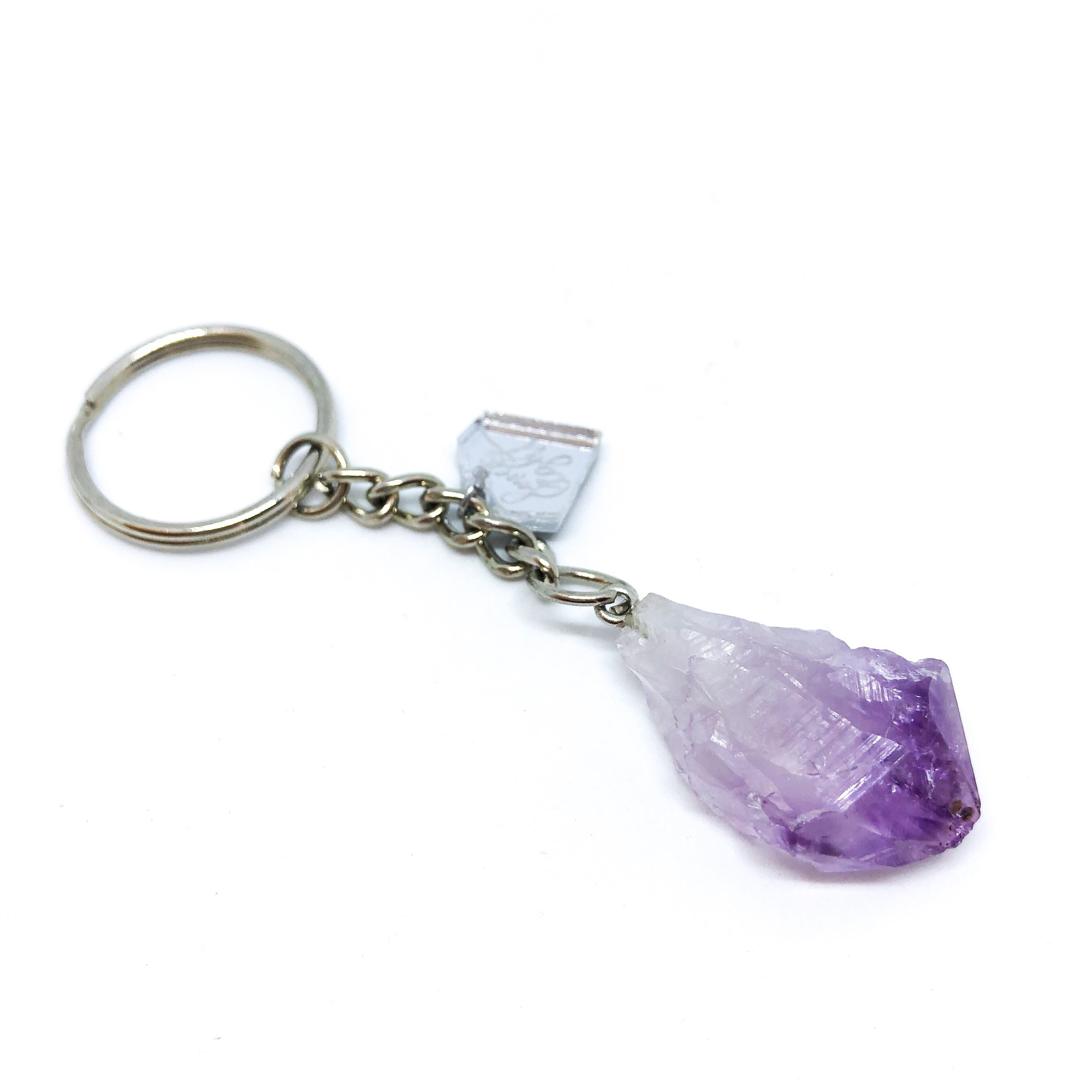 A collection of unique Raw Crystal Keychains featuring natural raw cut crystals in various shapes and sizes, accented with a silver LLJ charm.