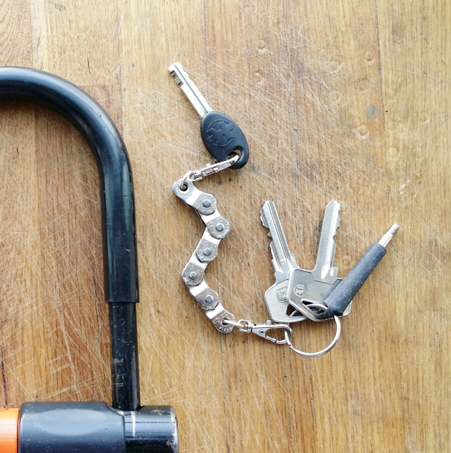 A handmade vegan keyring made from recycled bike chains, featuring a clasp and keyring for versatile use.