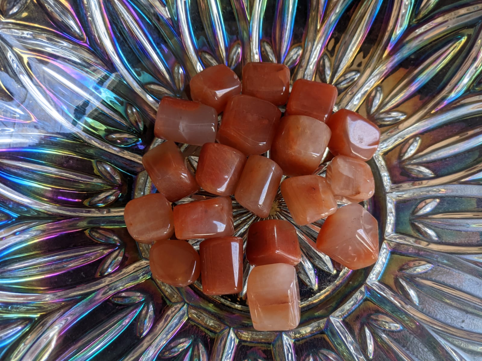 A collection of polished Red Carnelian gemstone tumbles showcasing their vibrant brownish-red color and smooth texture.