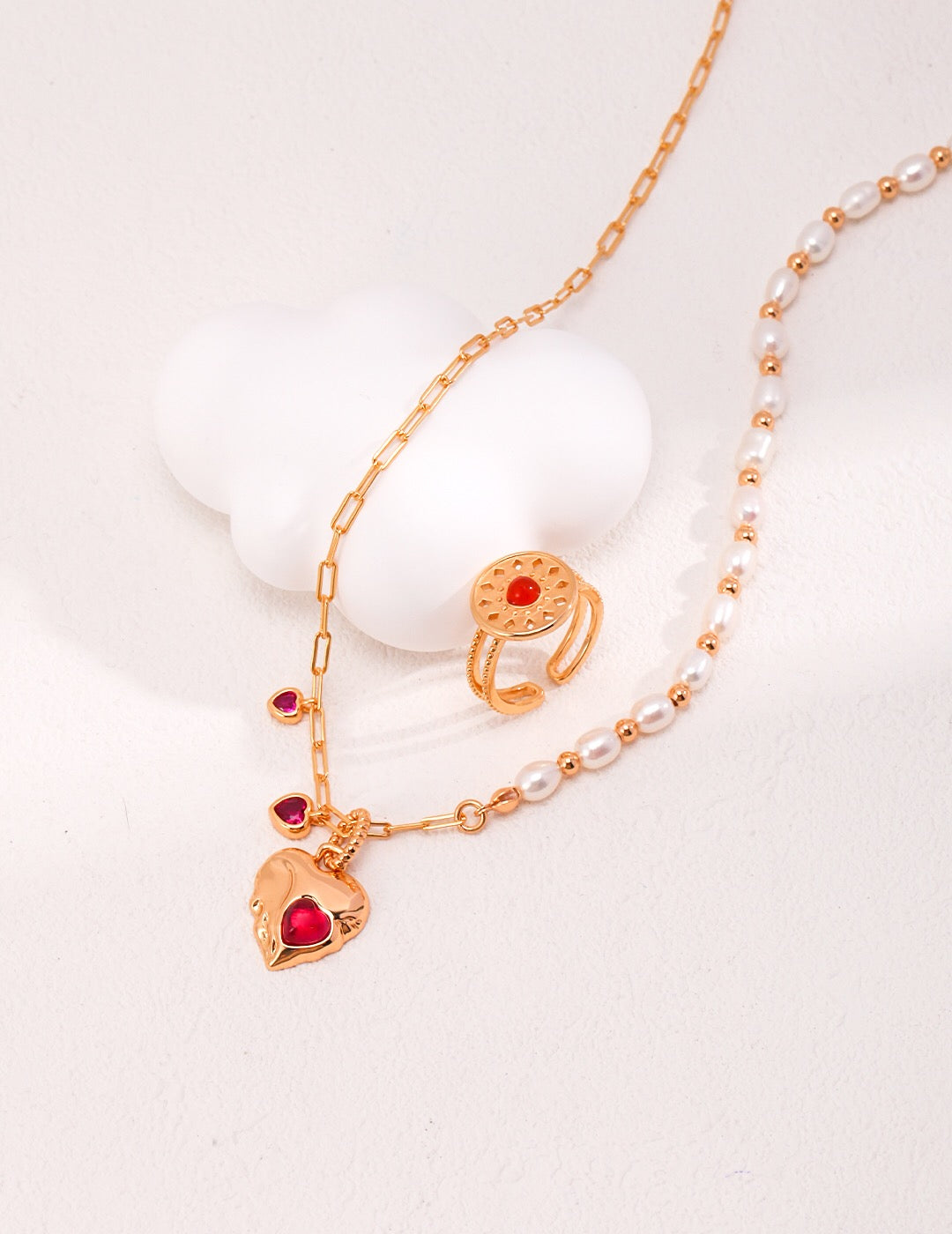 A stunning handmade necklace featuring a red corundum heart pendant and natural pearls, elegantly displayed on a soft background.