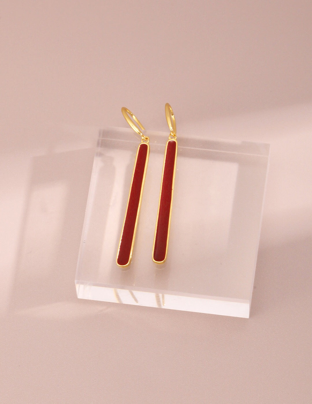 A pair of handmade red dripping glaze earrings with gold vermeil accents, showcasing a unique and elegant design.