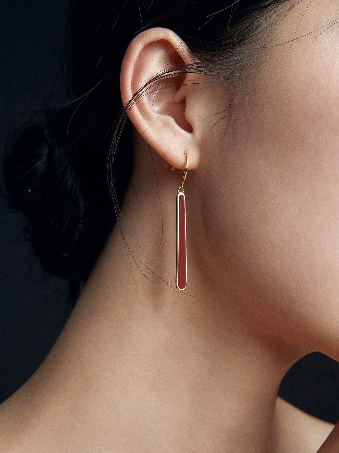 A pair of handmade red dripping glaze earrings with gold vermeil accents, showcasing a unique and elegant design.