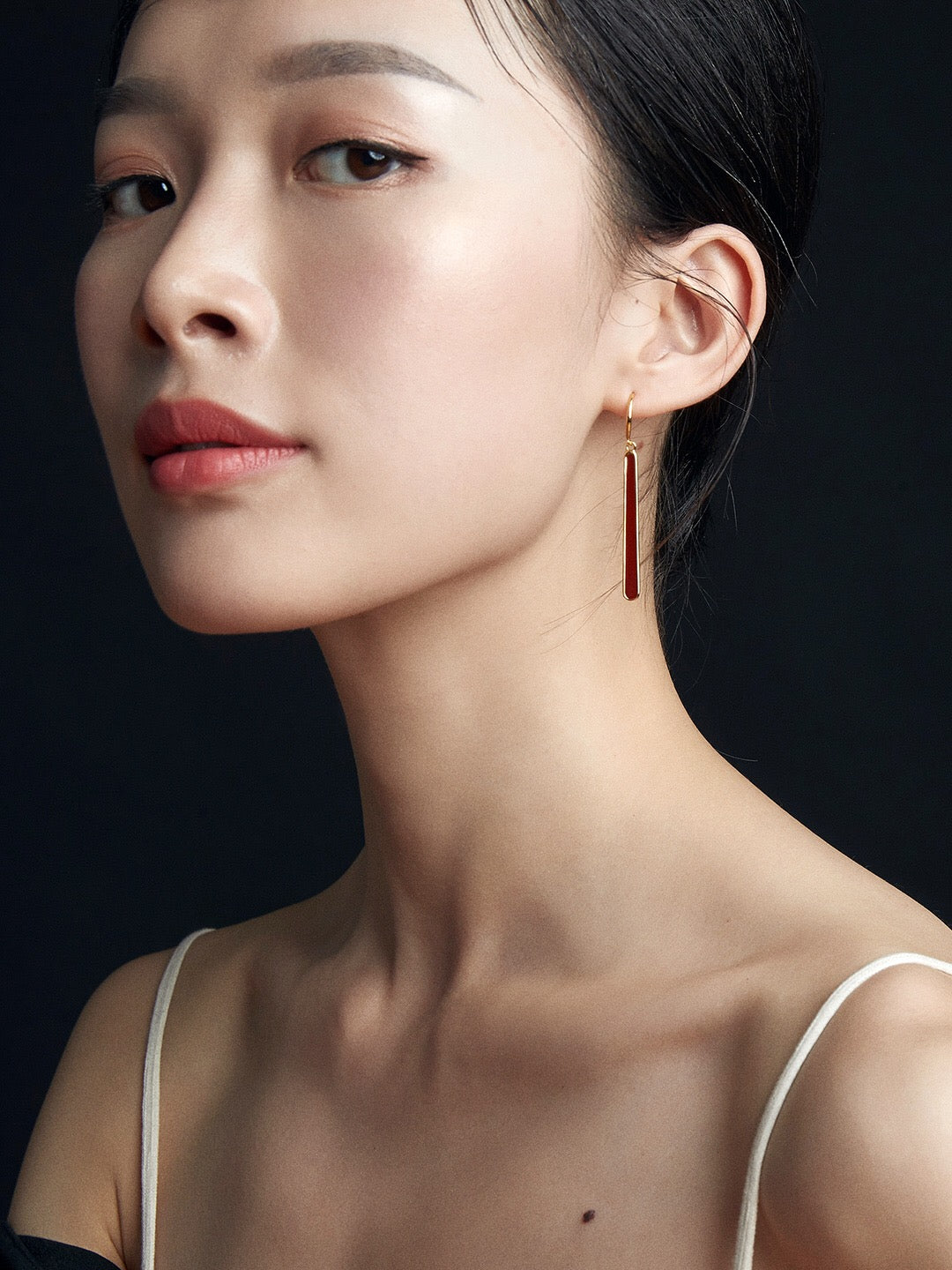 A pair of handmade red dripping glaze earrings with gold vermeil accents, showcasing a unique and elegant design.